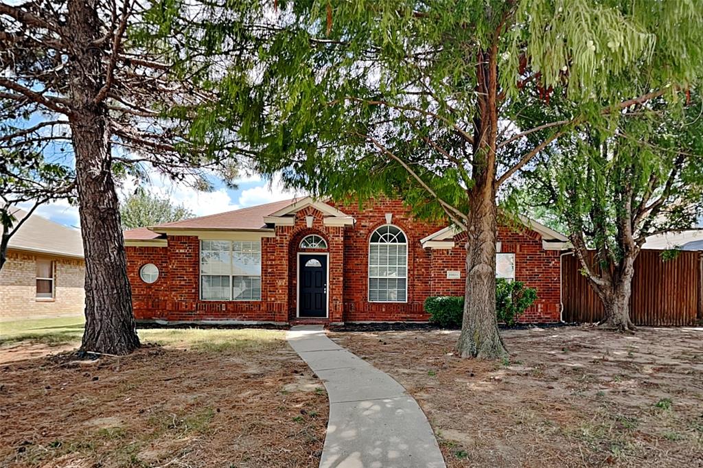 a front view of a house with a tree in front