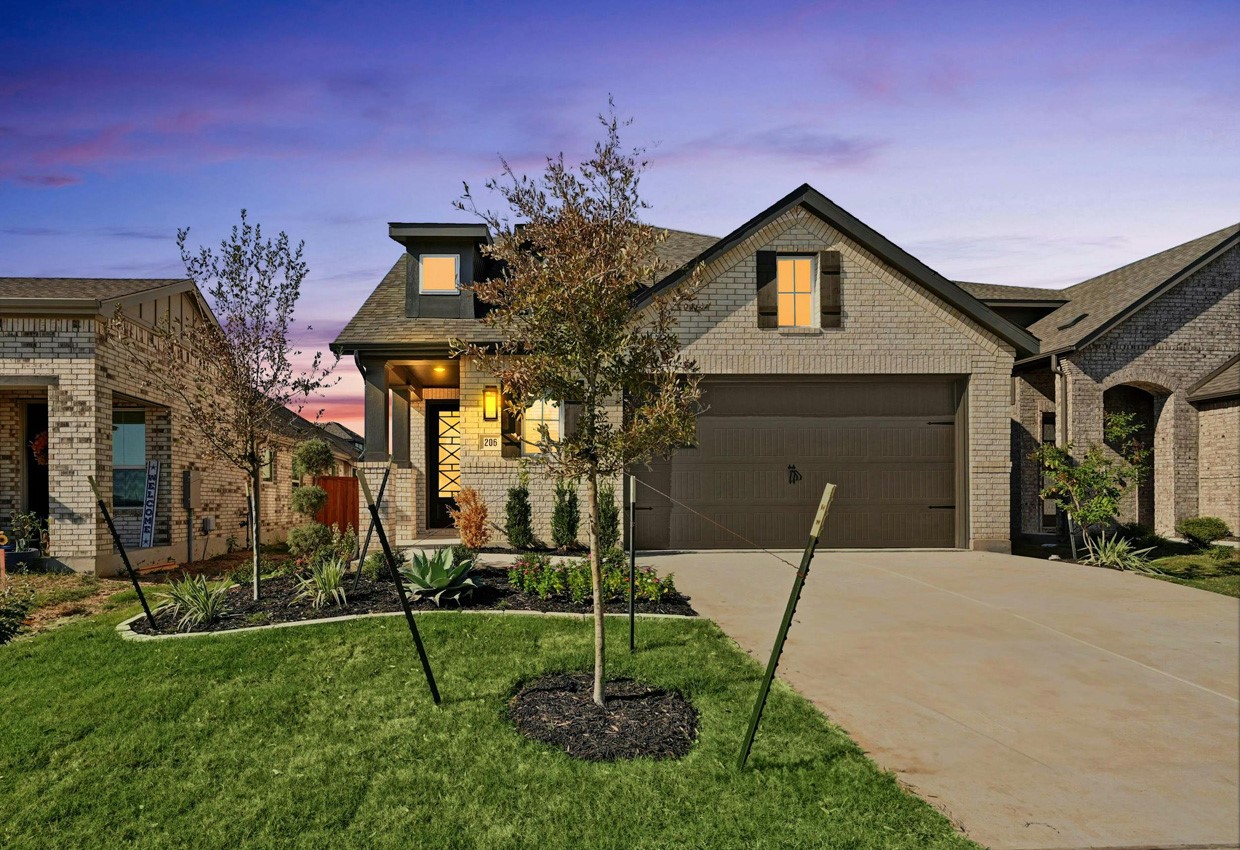 a front view of a house with a yard and garage