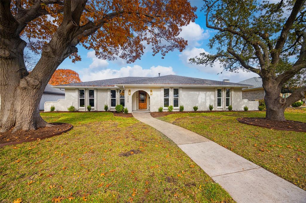 a front view of a house with yard and green space