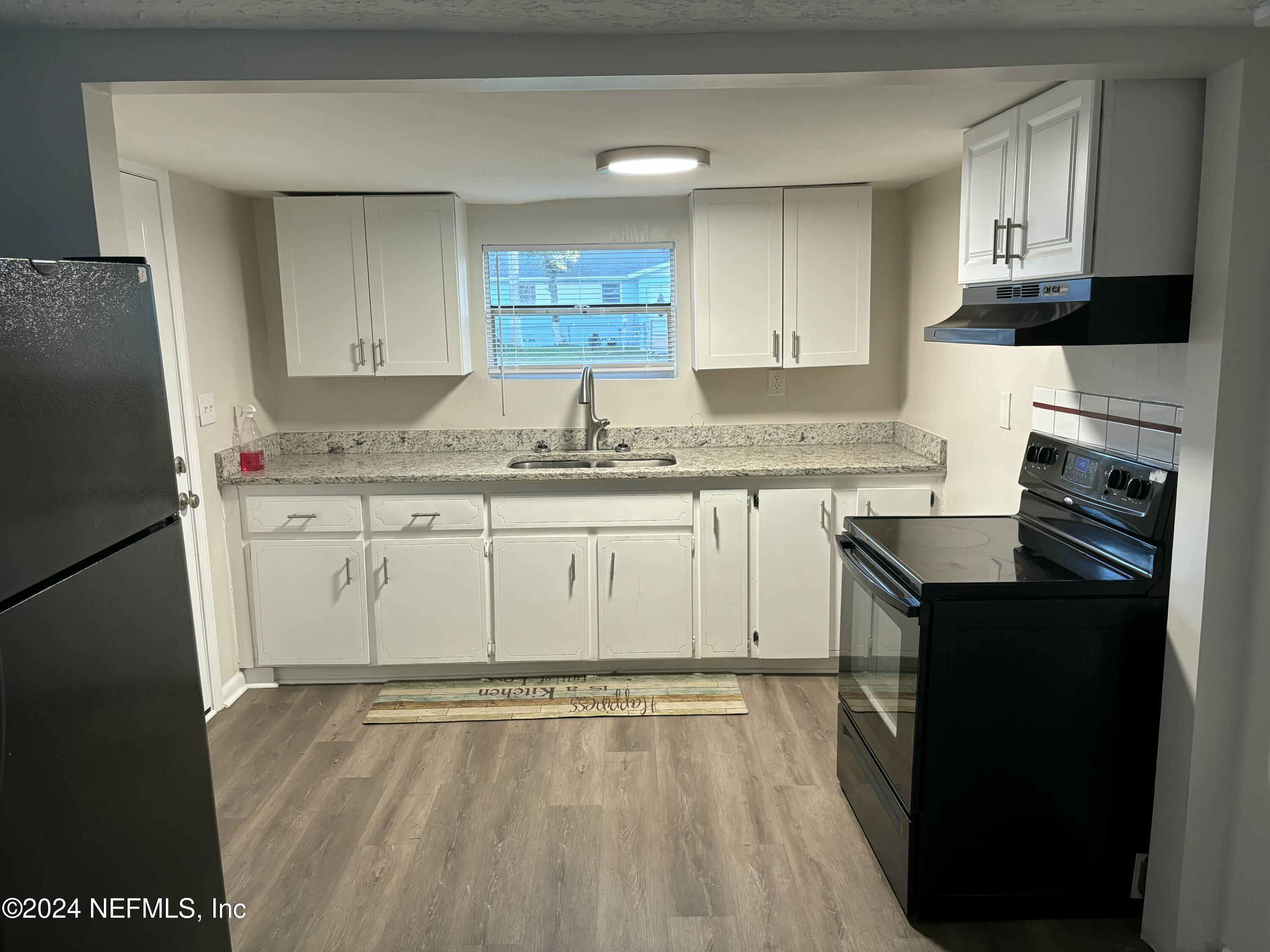 a kitchen with a sink a stove a refrigerator and cabinets