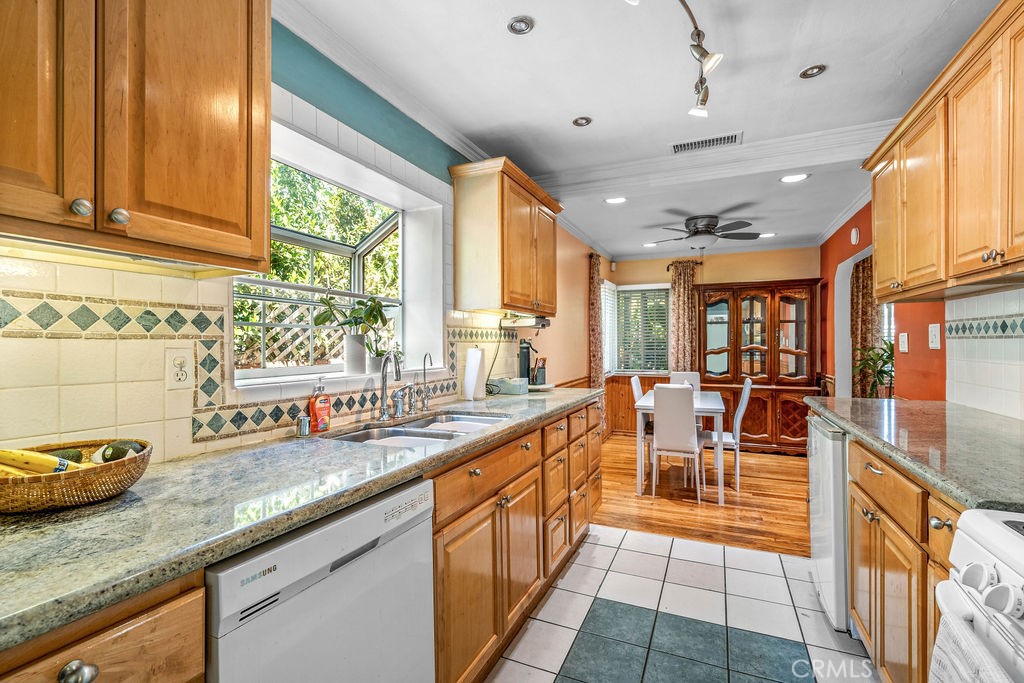 a view of a kitchen with granite countertop a large window and stainless steel appliances