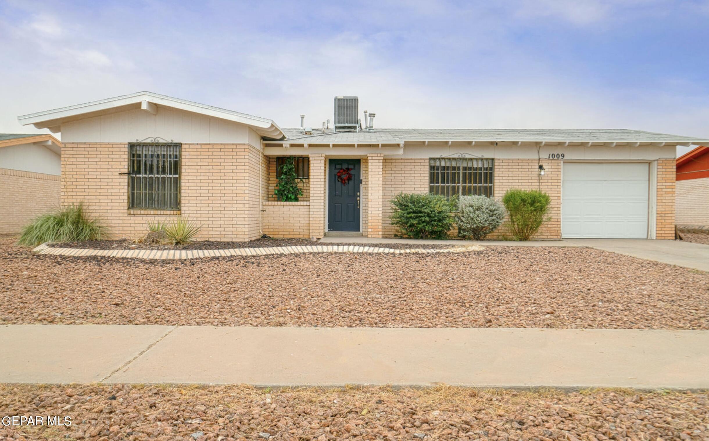 a front view of a house with a yard and potted plants