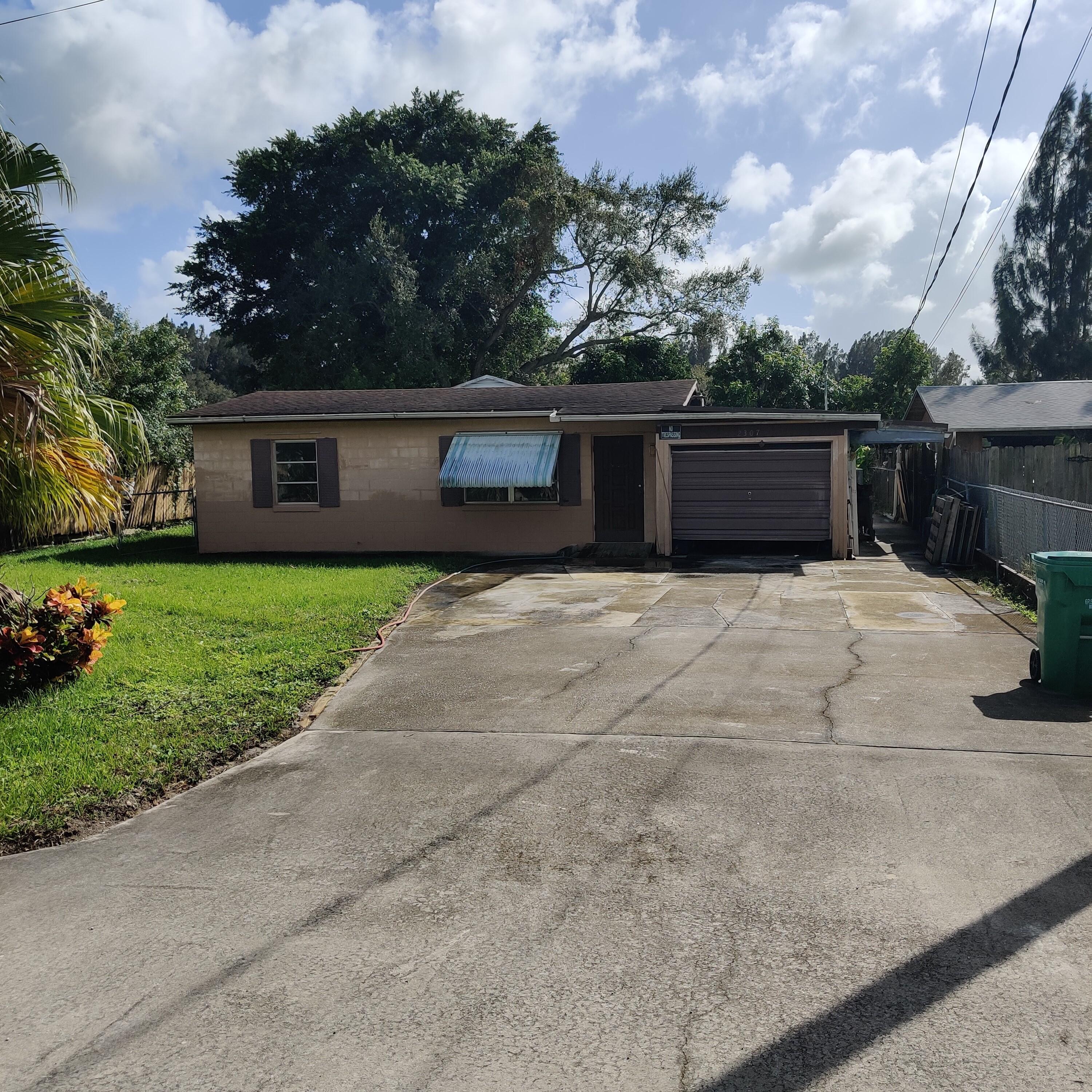 a front view of house with yard and trees in the background