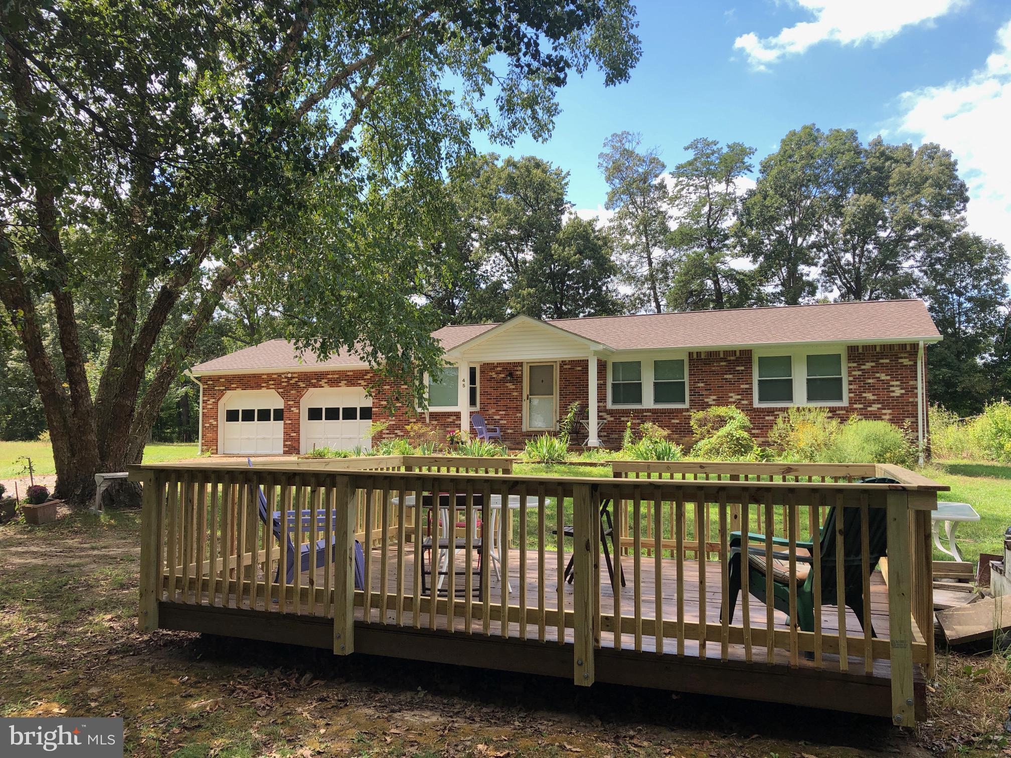 a view of a house with wooden deck and a trees