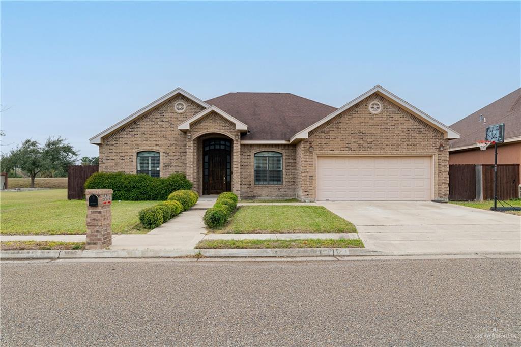 View of front facade featuring a garage and a front lawn