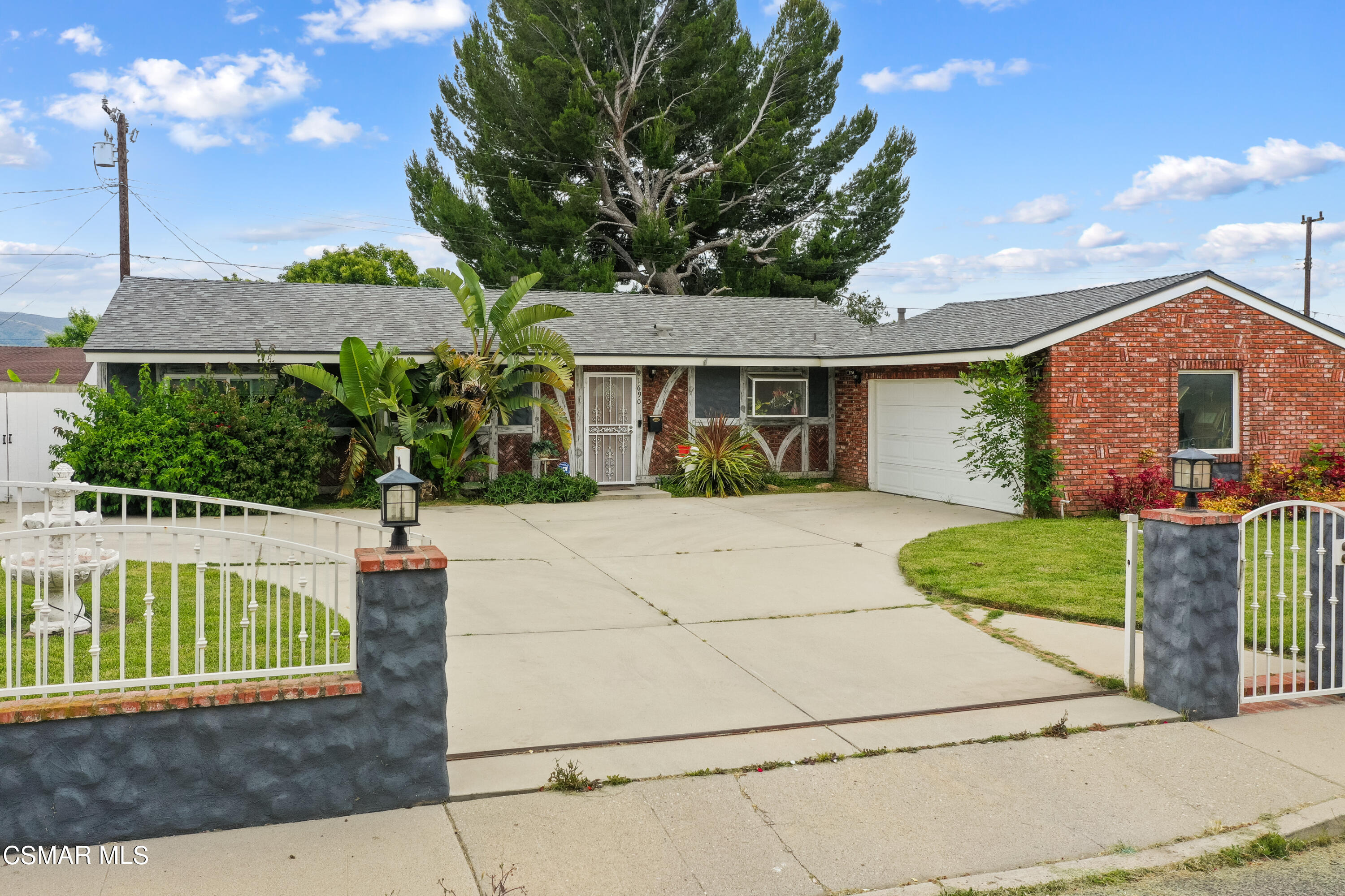 a front view of a house with a yard and potted plants