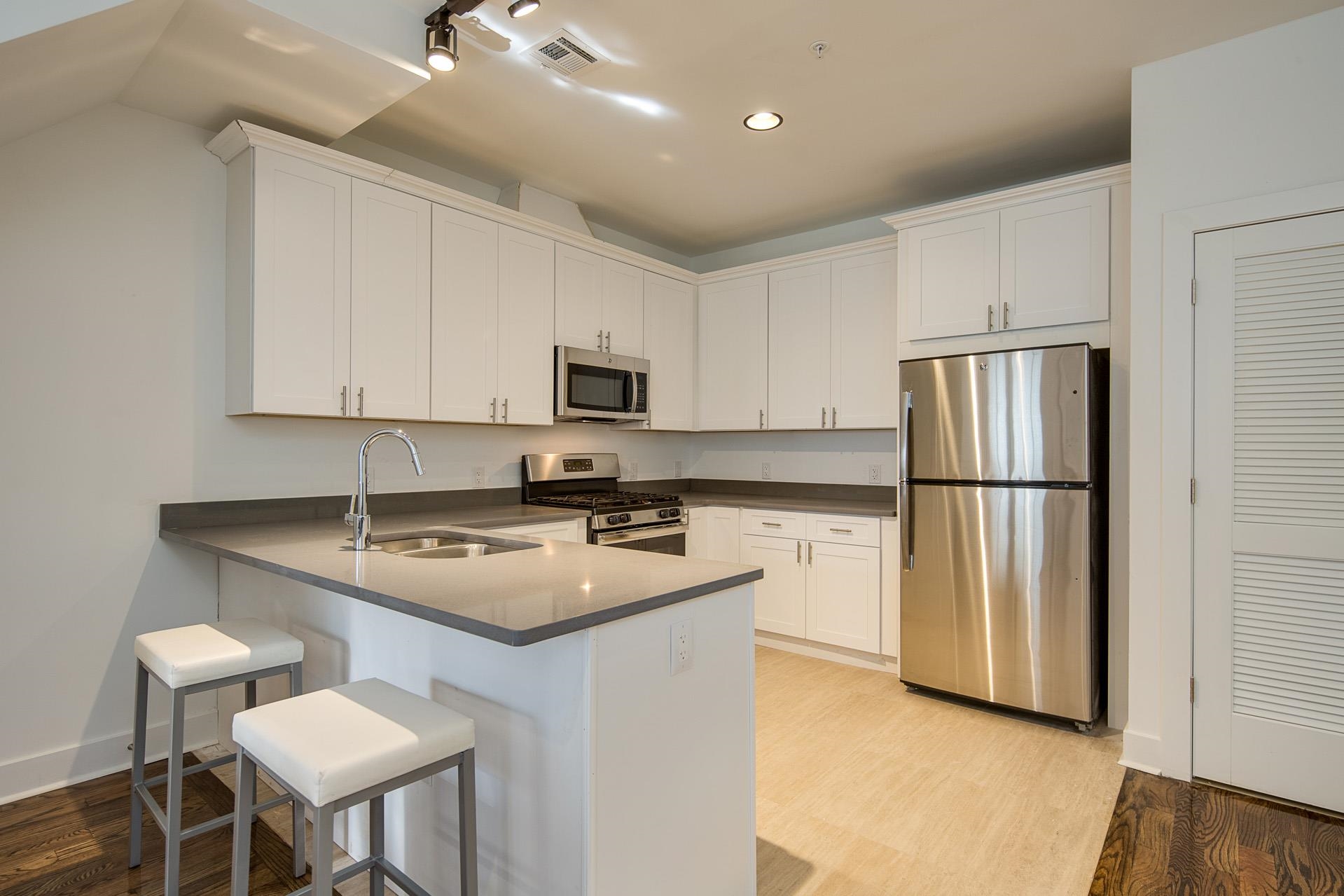 a kitchen with a refrigerator a stove a sink and a dining table