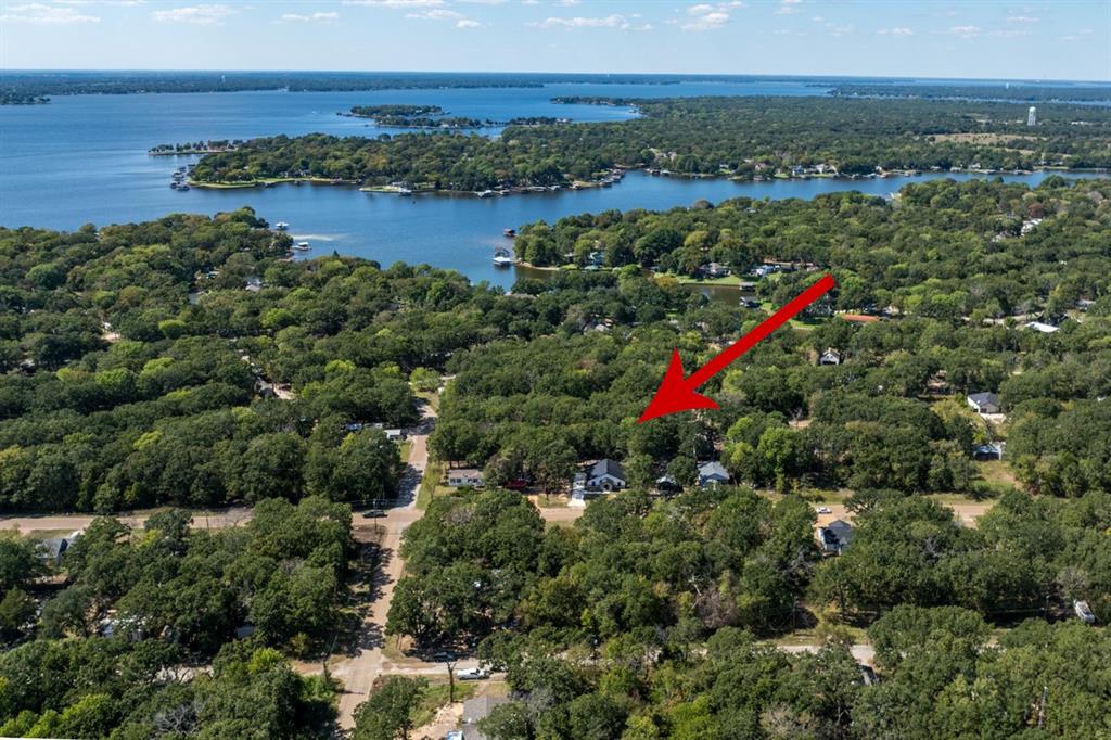 an aerial view of residential houses with outdoor space and lake