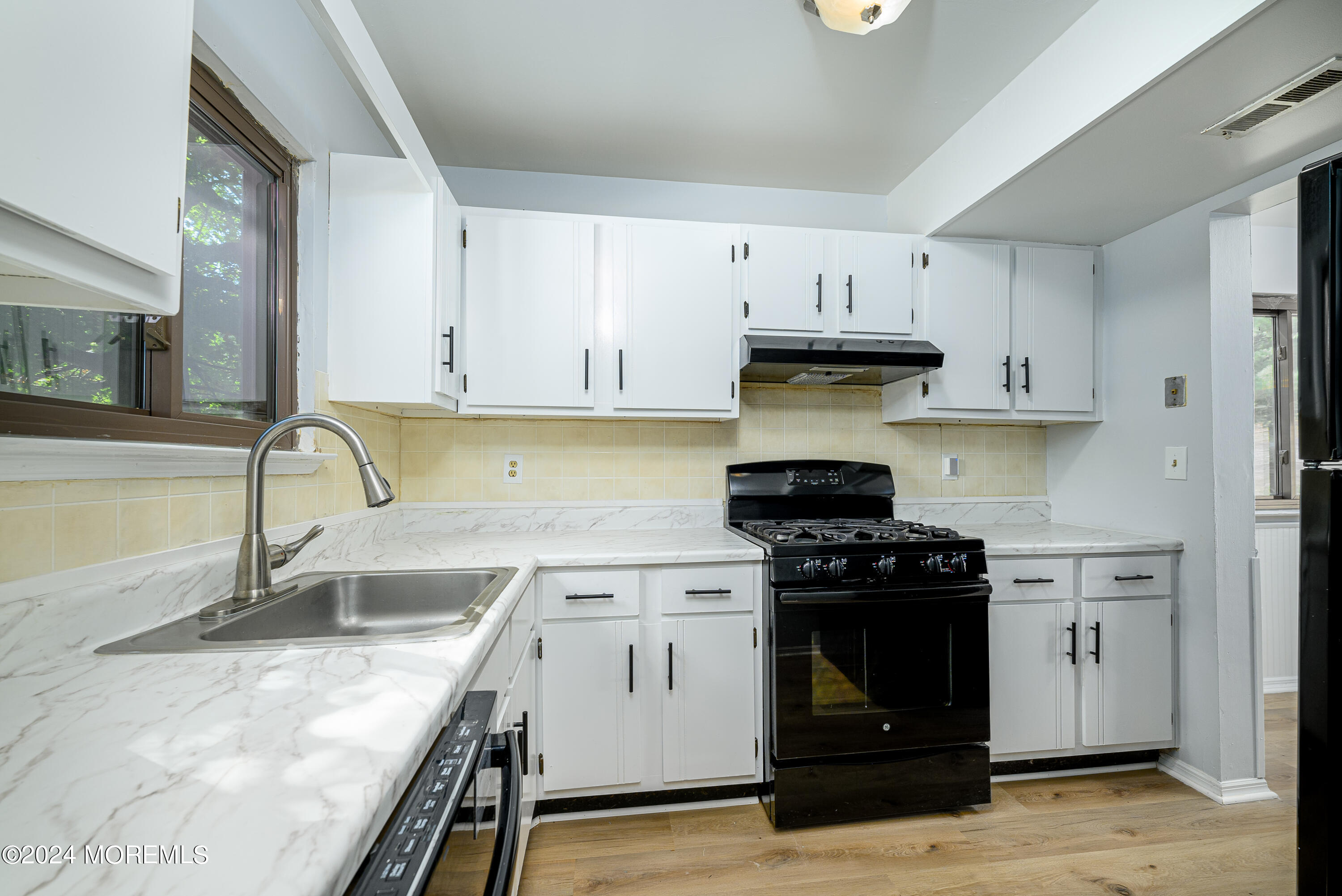 a kitchen with granite countertop a stove and a sink