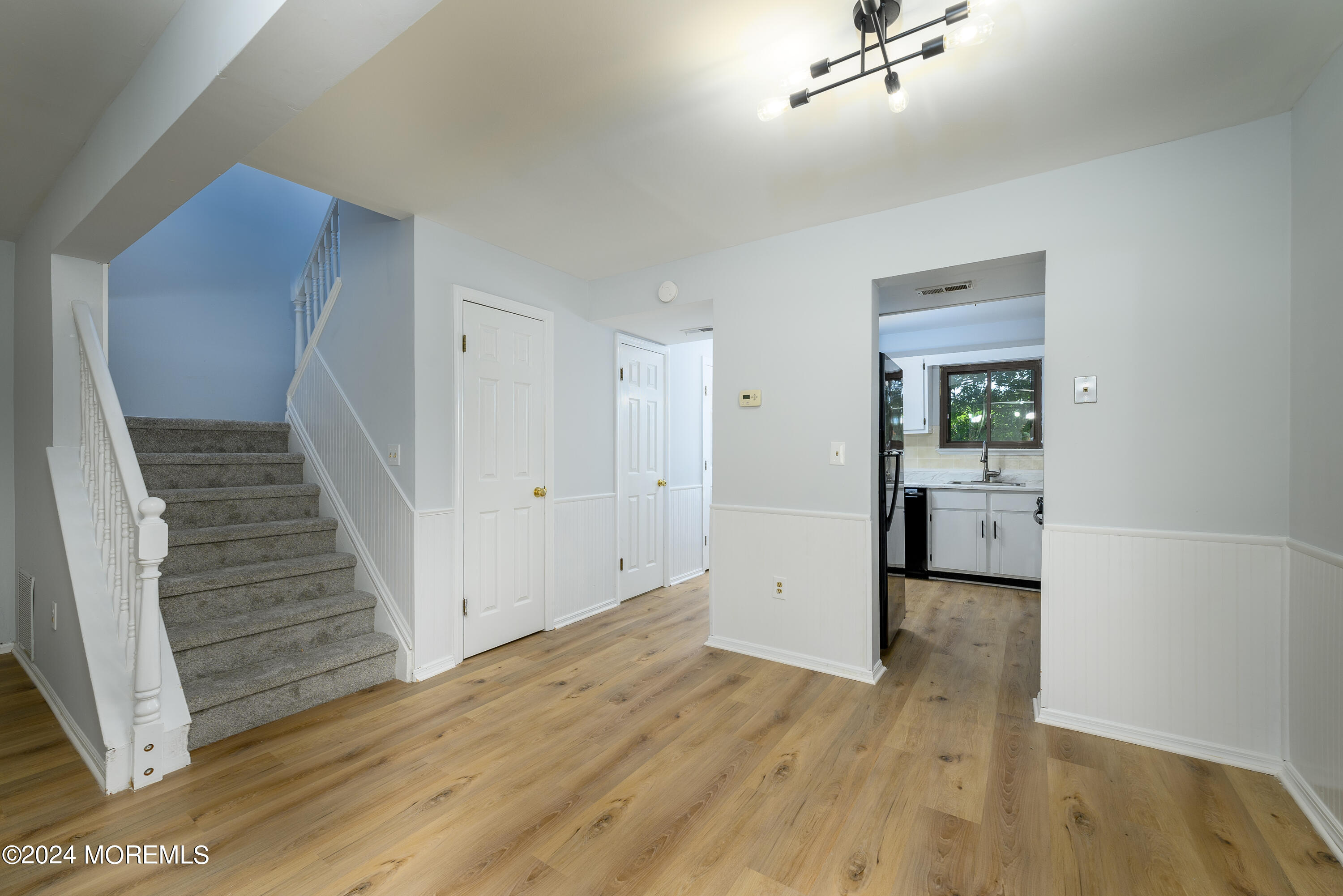 a view of a hallway with wooden floor and staircase