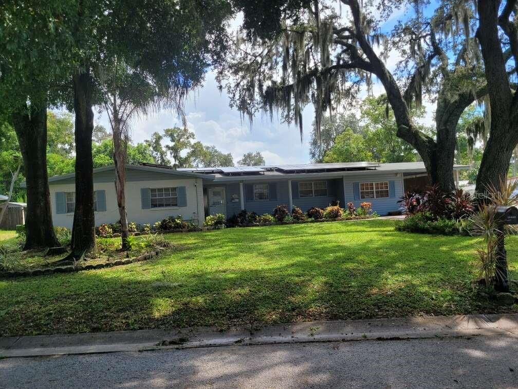 a front view of house with a garden and trees