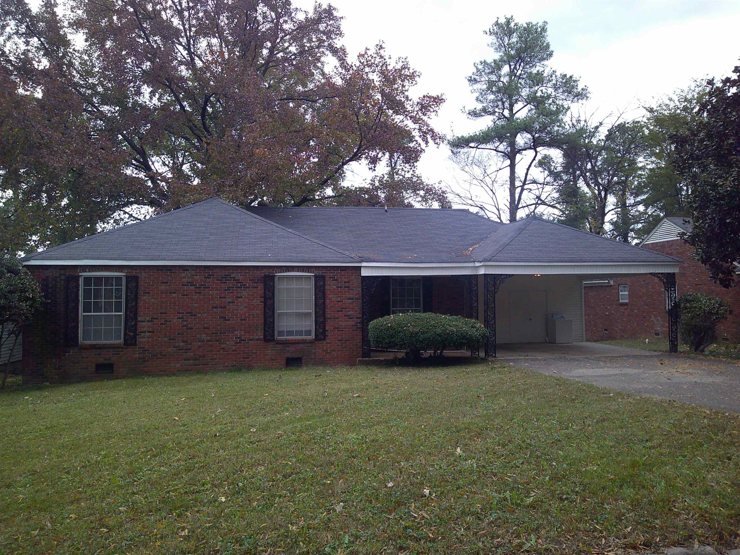 Single story home with a front yard and a carport