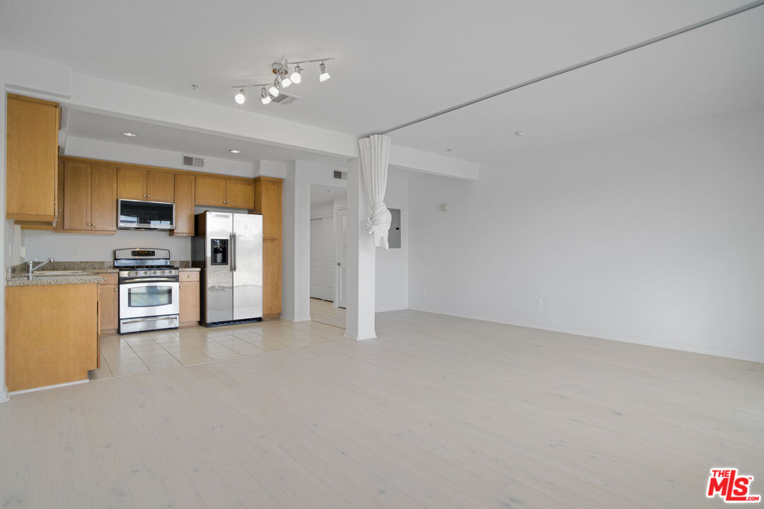 a view of kitchen with refrigerator cabinets and furniture