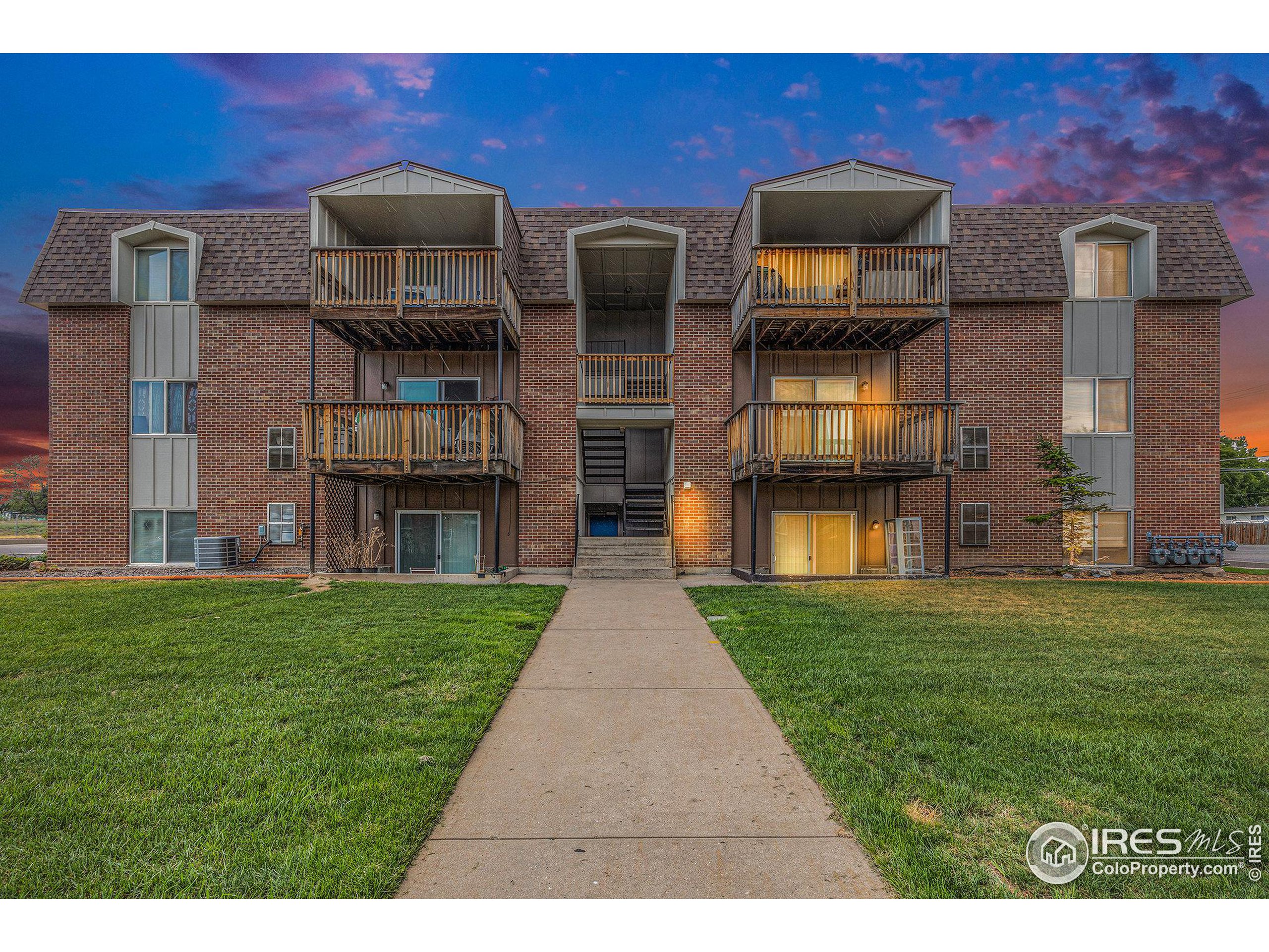 a front view of a residential apartment building with a yard