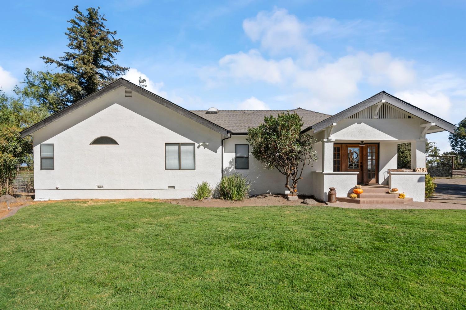 a front view of a house with a yard and trees