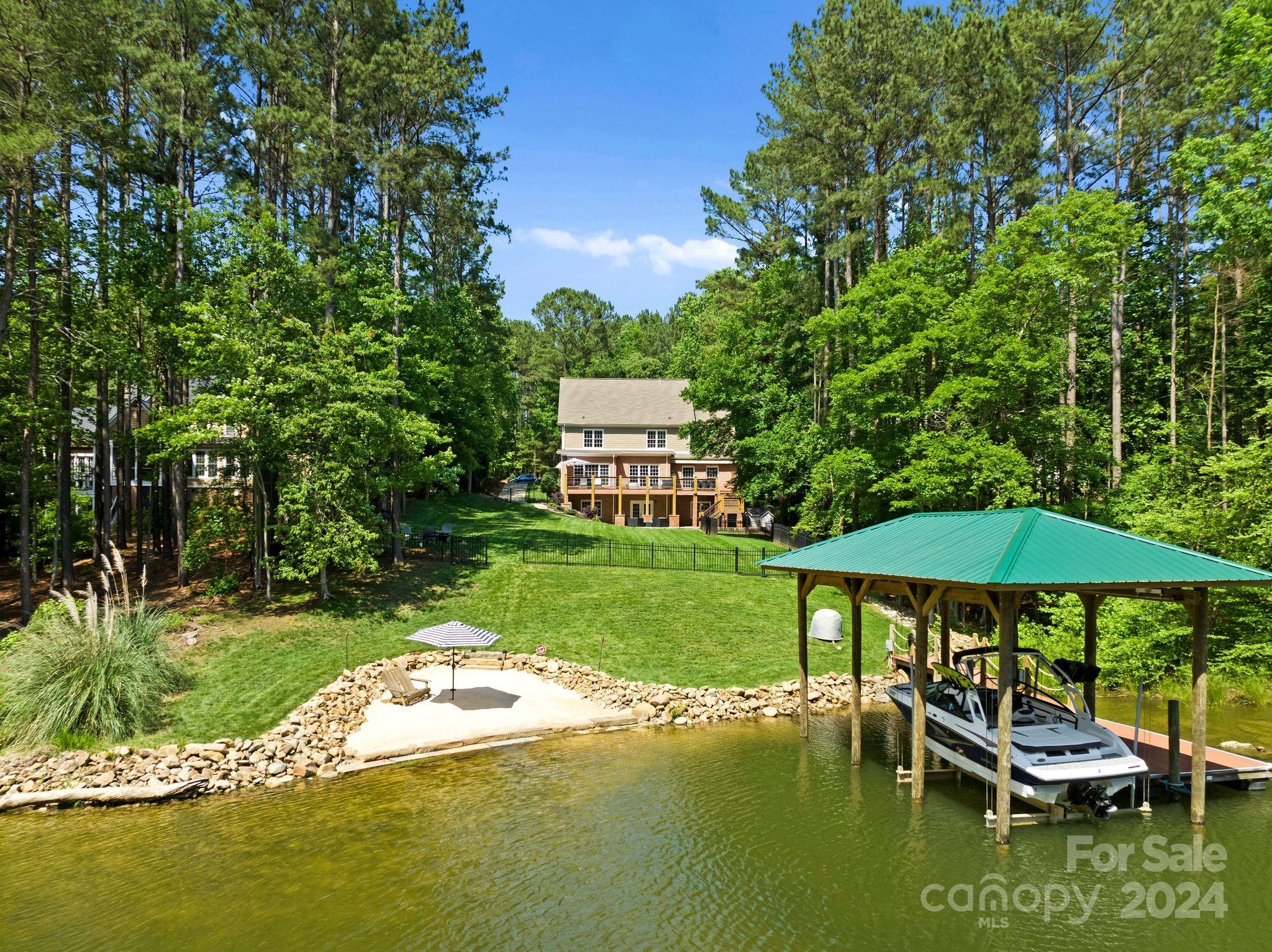 a view of a swimming pool and lounge chairs in back yard of the house