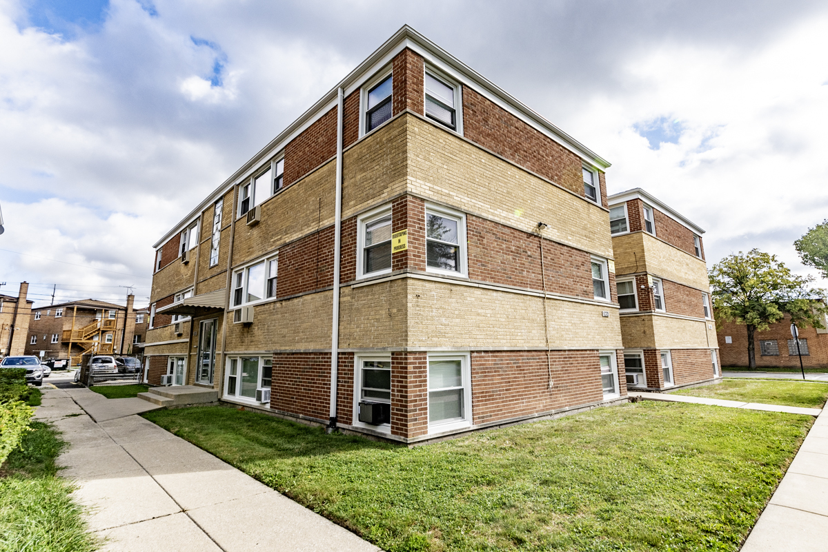 a large building with a small yard and more windows