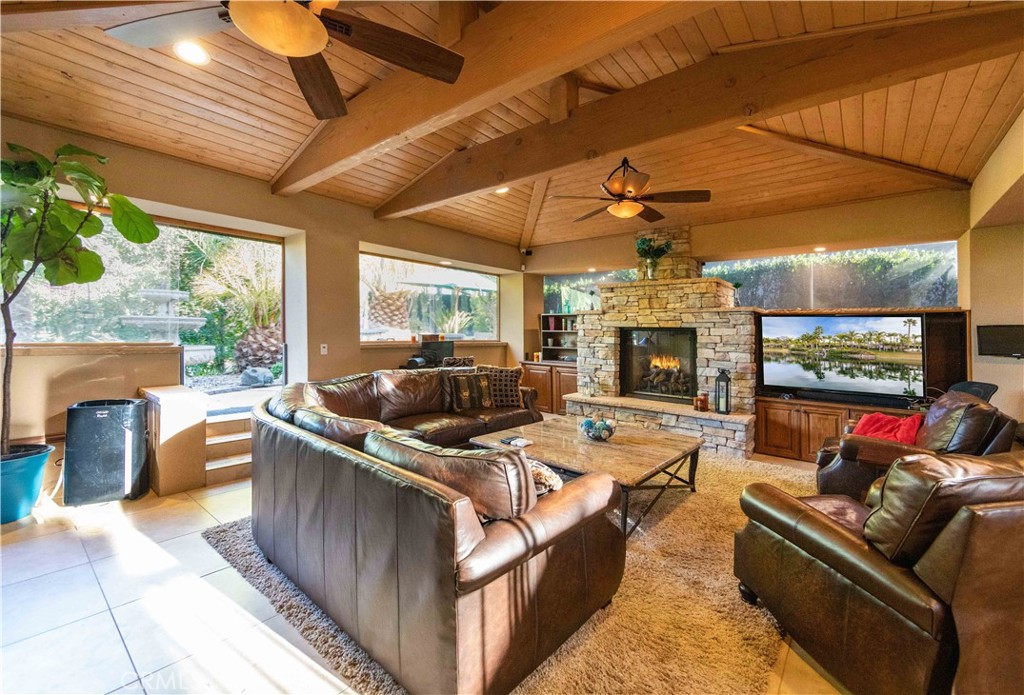 a living room with furniture a fireplace and a ceiling fan