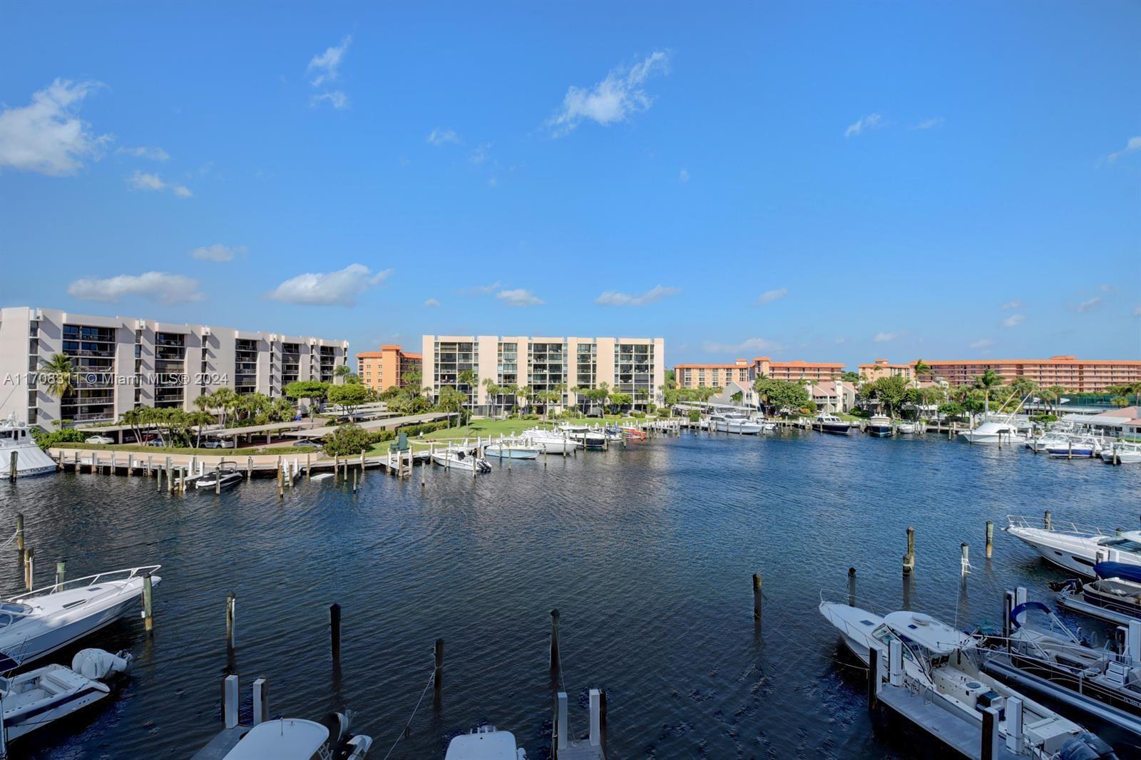 a view of an ocean with boats and trees in the background