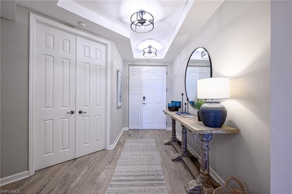 a view of a hallway with entryway wooden floor and front door