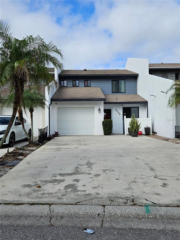 a view of a house with a yard and palm trees