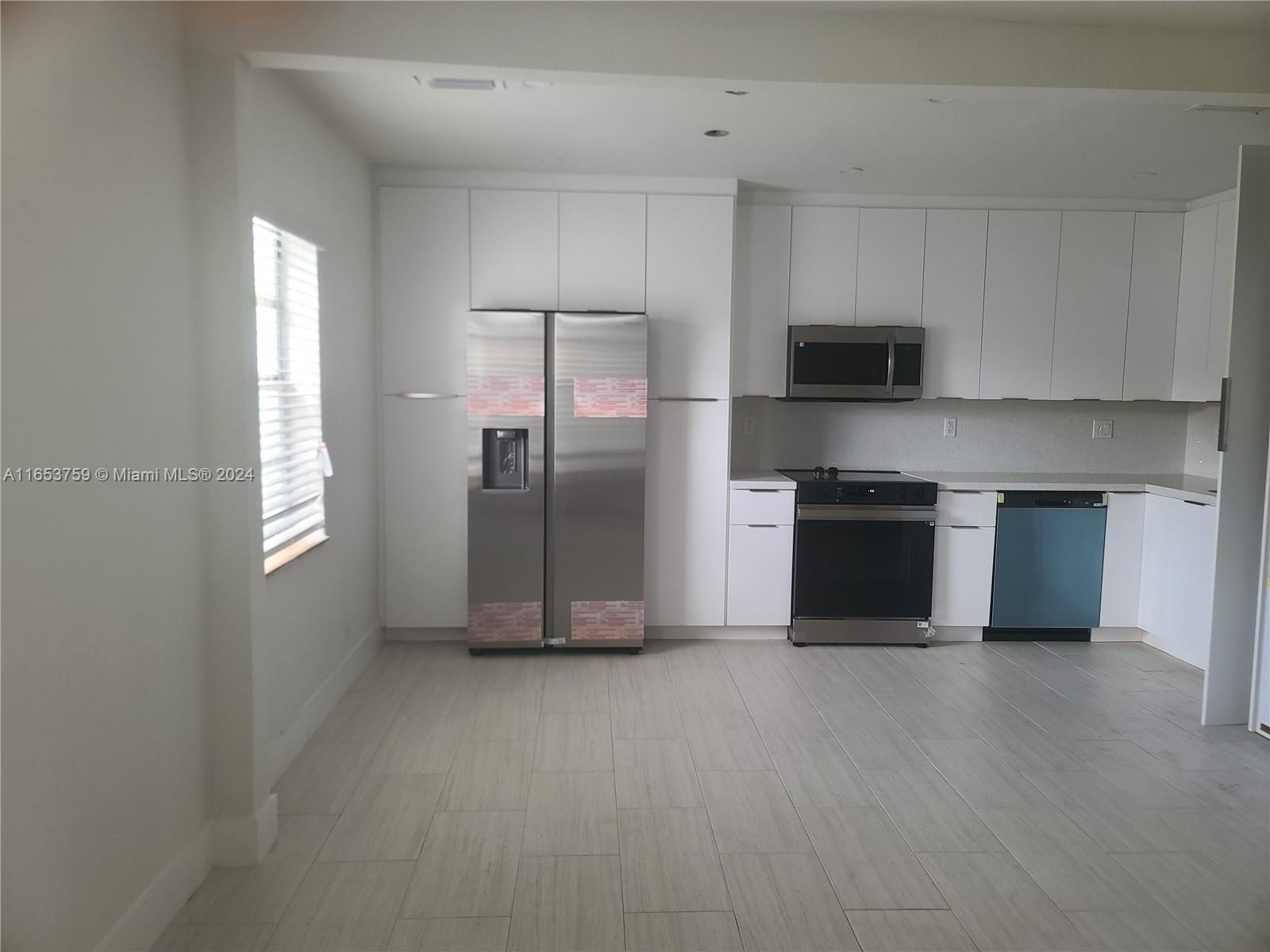 a kitchen with stainless steel appliances a refrigerator and a stove top oven