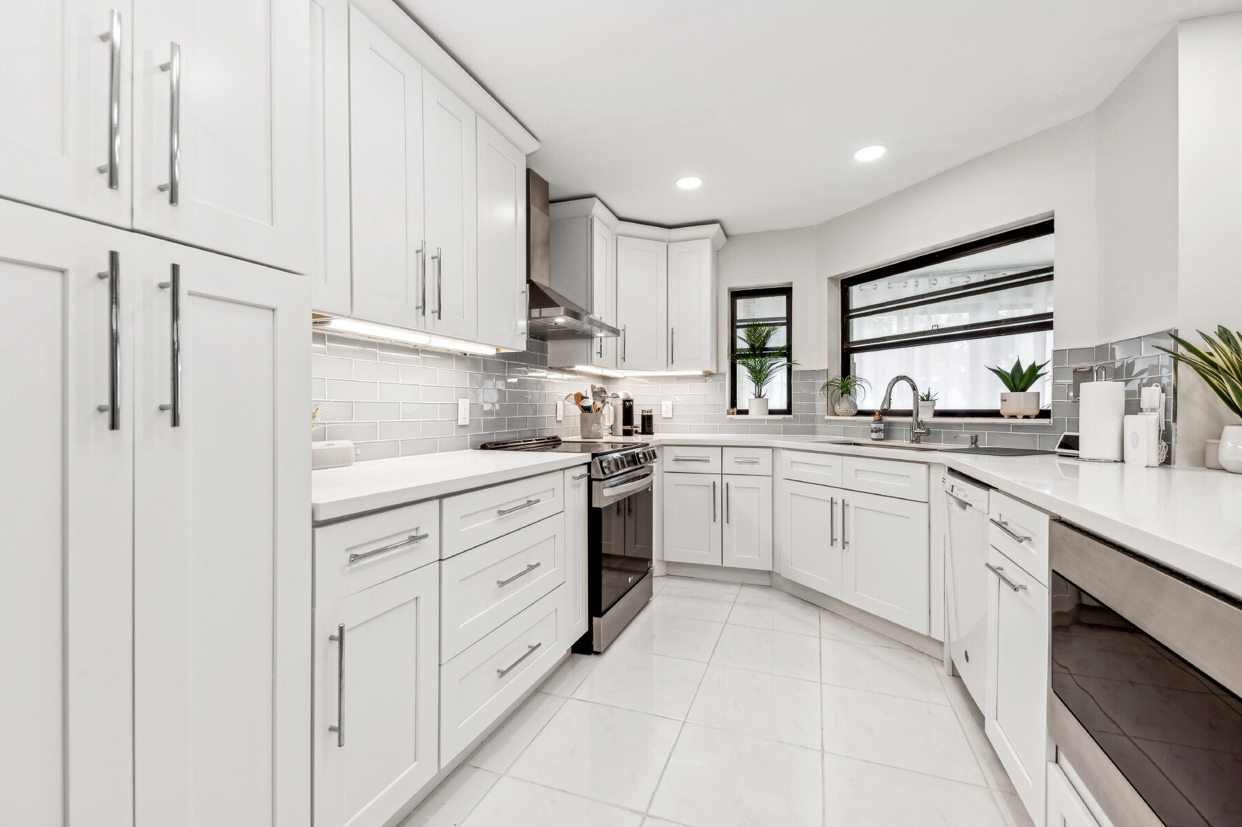 a kitchen with cabinets appliances a sink and a window