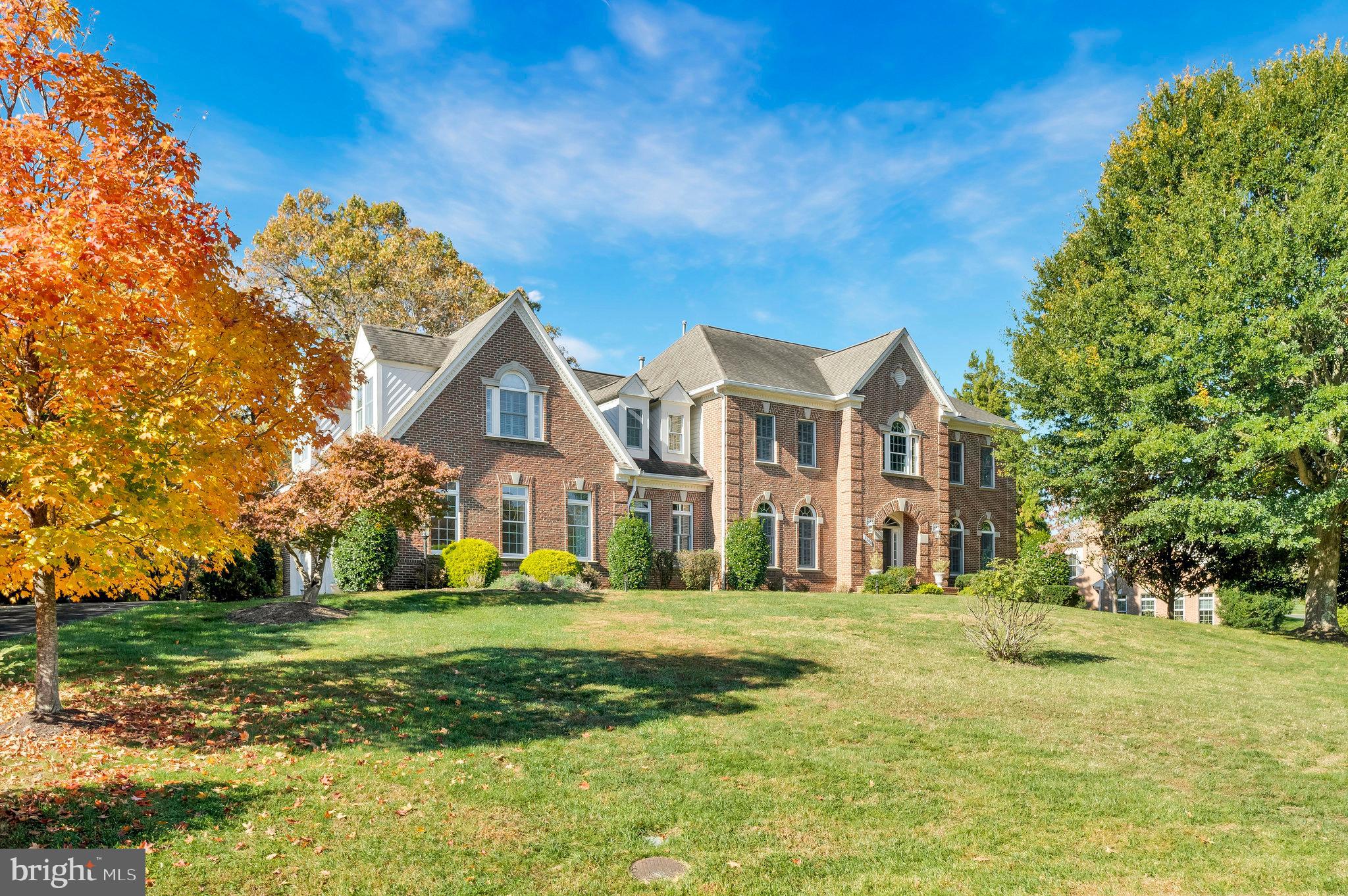 a view of a big house with a big yard and large trees