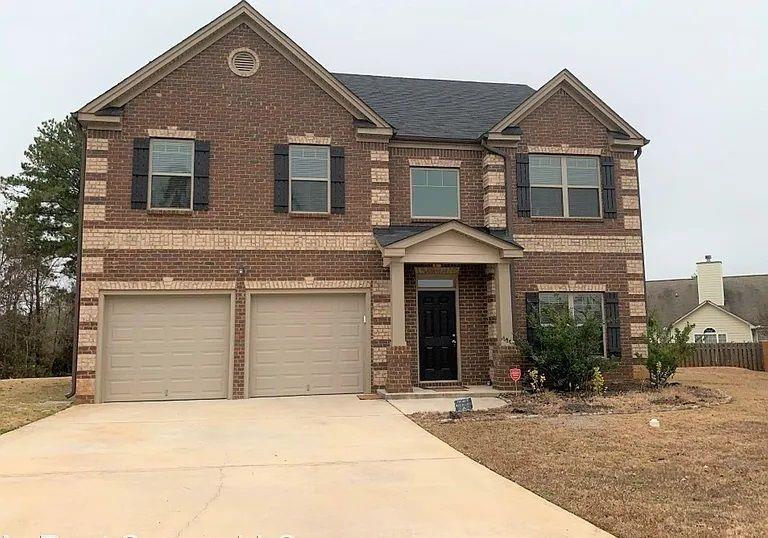 a front view of a house with a yard and garage