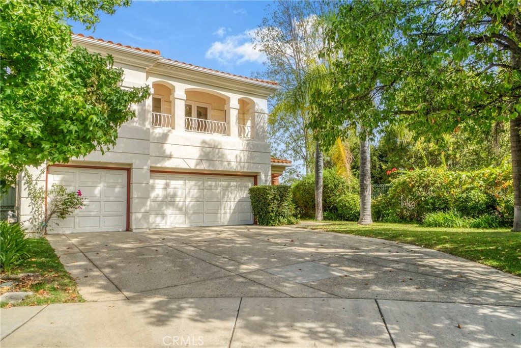 a front view of a house with a yard and trees