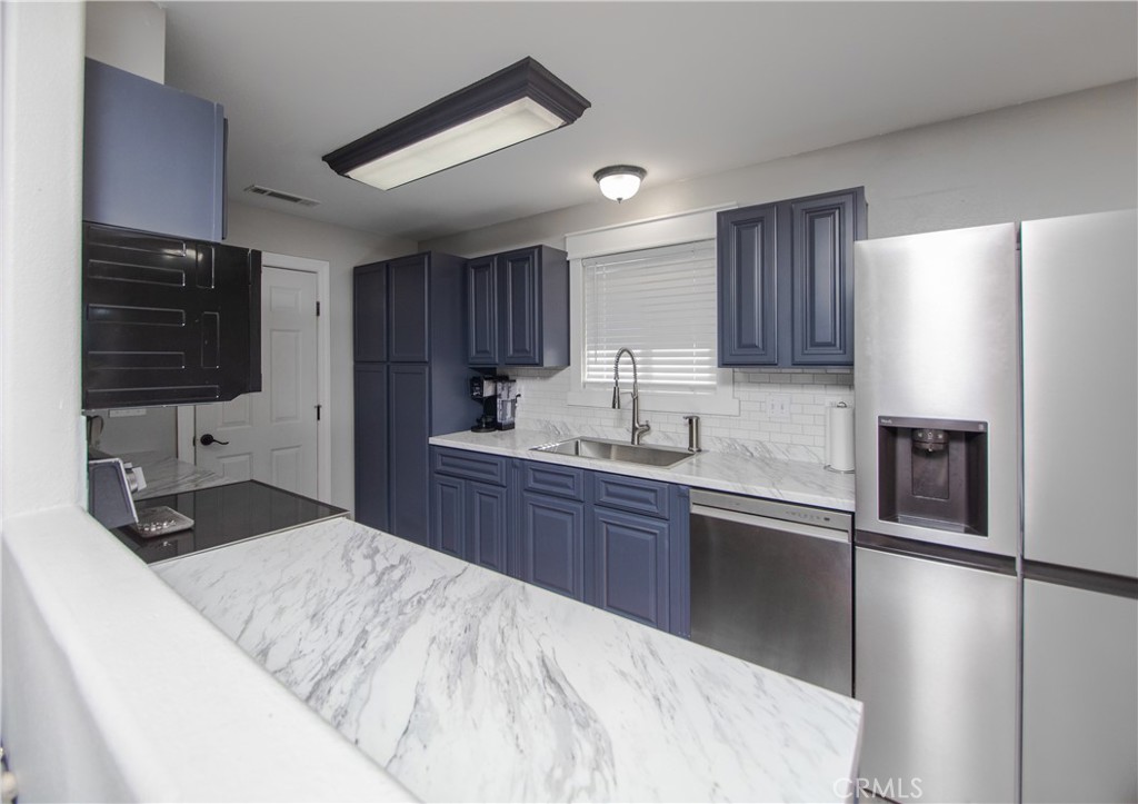 a kitchen with stainless steel appliances granite countertop a sink refrigerator and cabinets