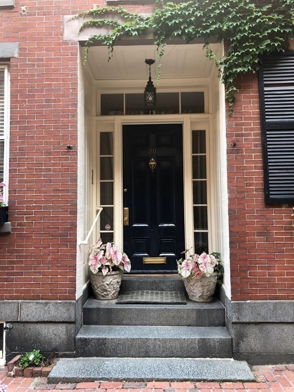 a front view of a house with potted plants