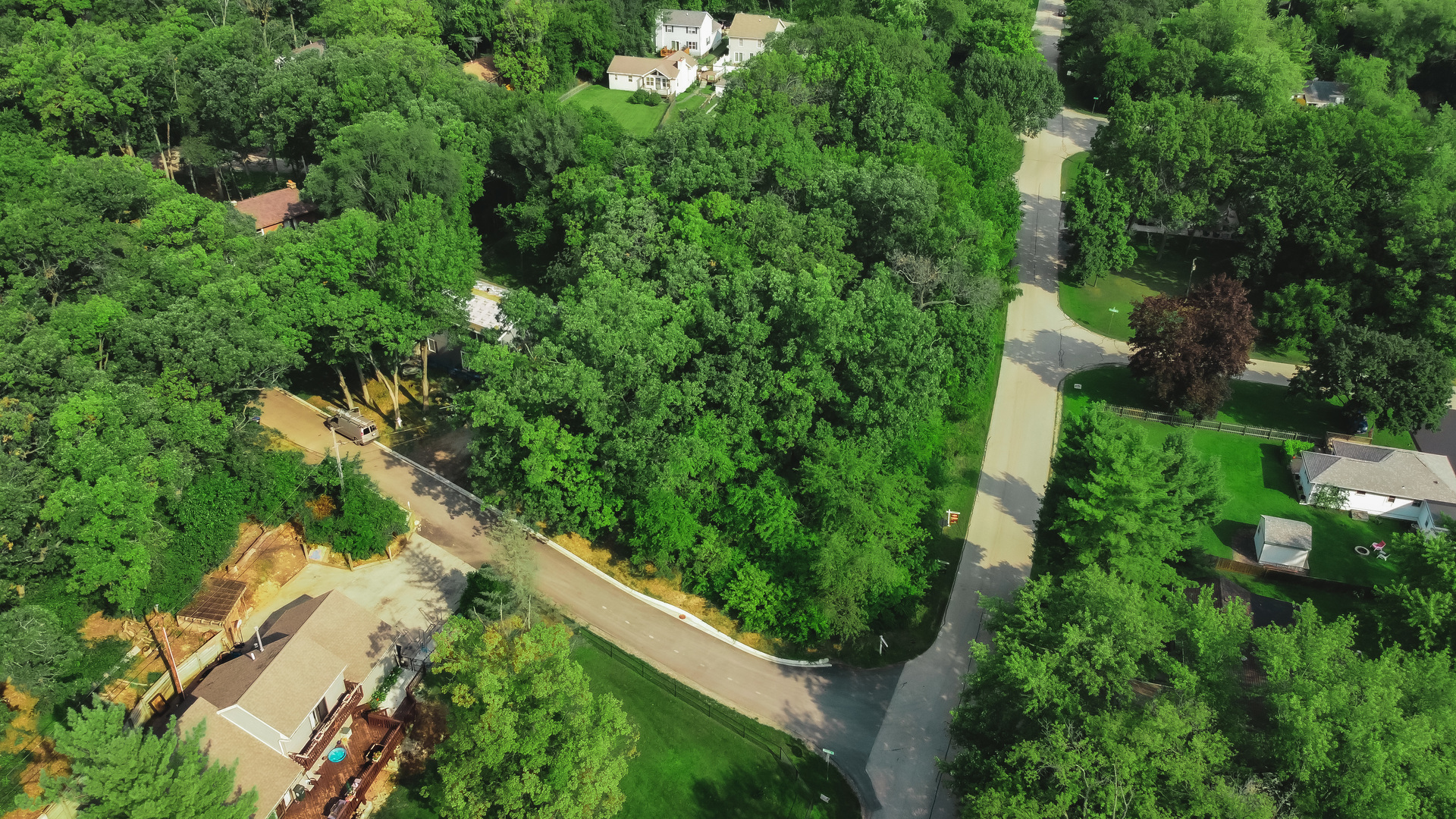 an aerial view of residential house with outdoor space and trees all around