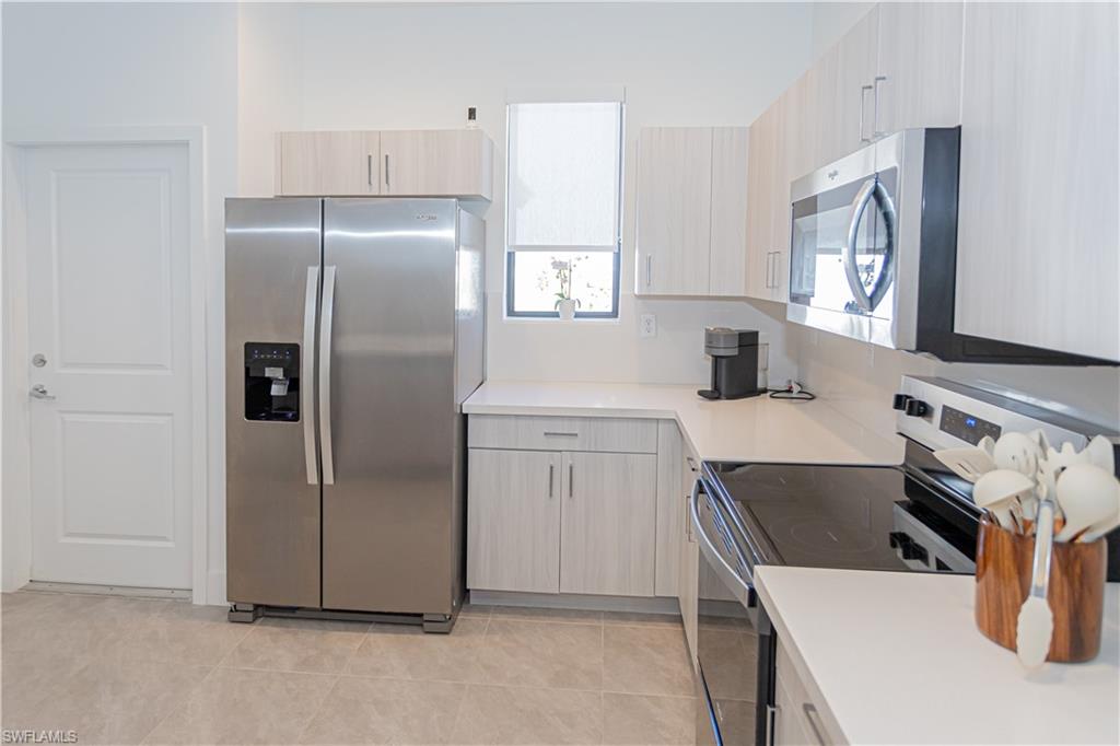 a kitchen with a refrigerator sink and white cabinets