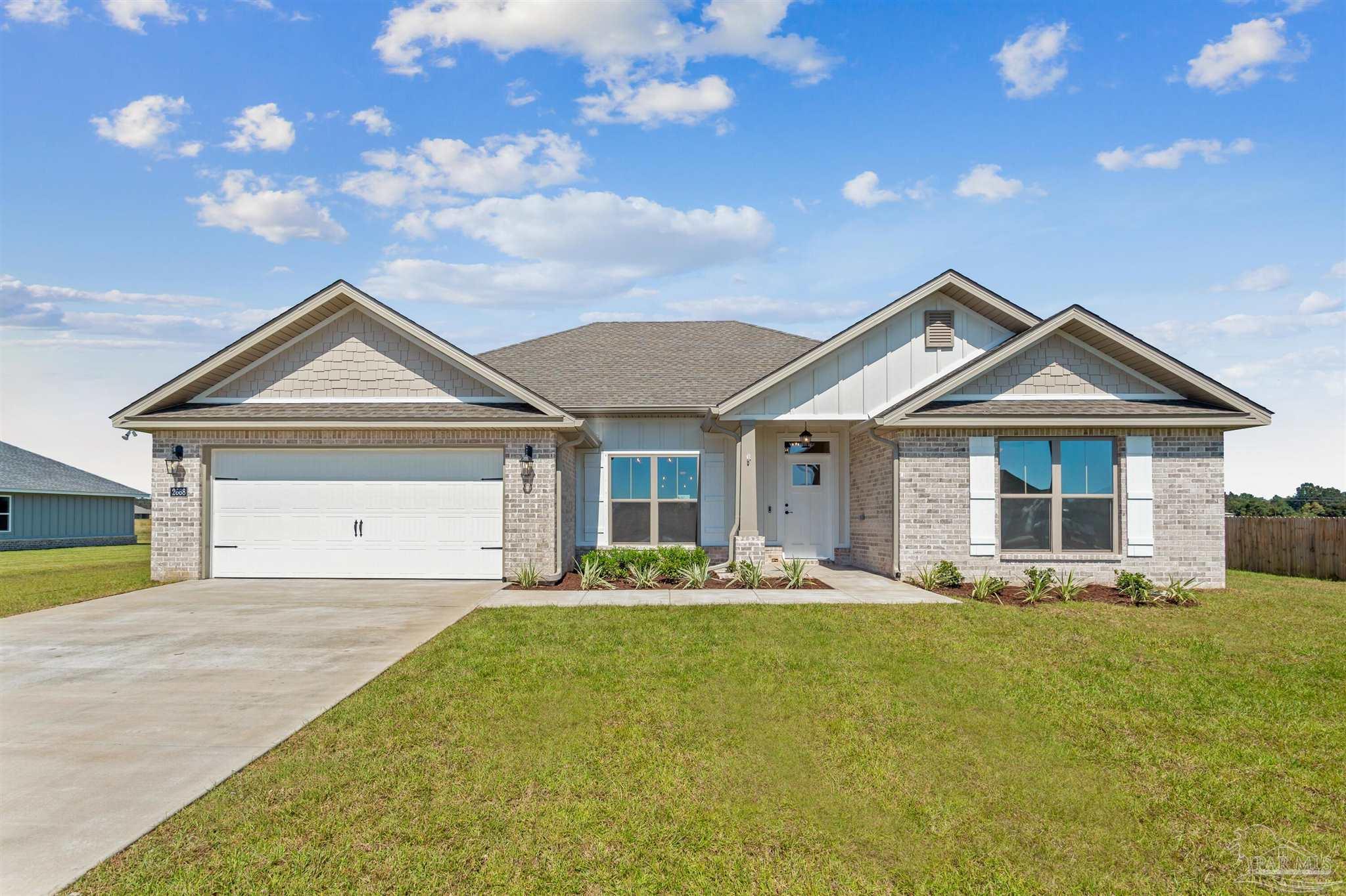 a front view of a house with a yard outdoor seating and garage