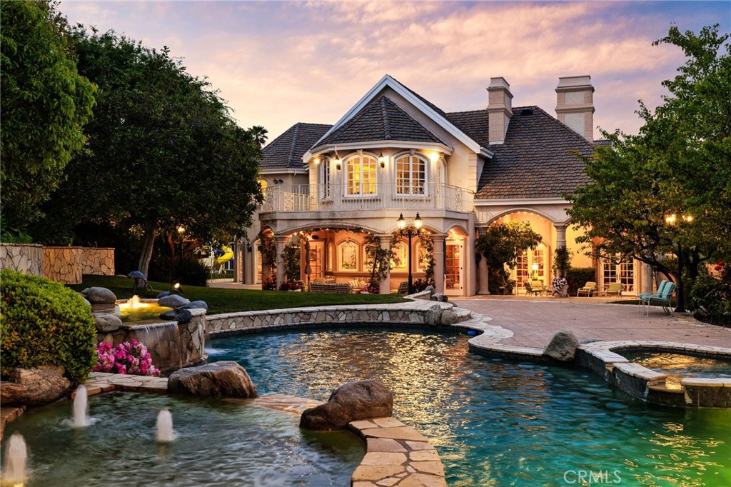 a front view of a house with swimming pool and a yard