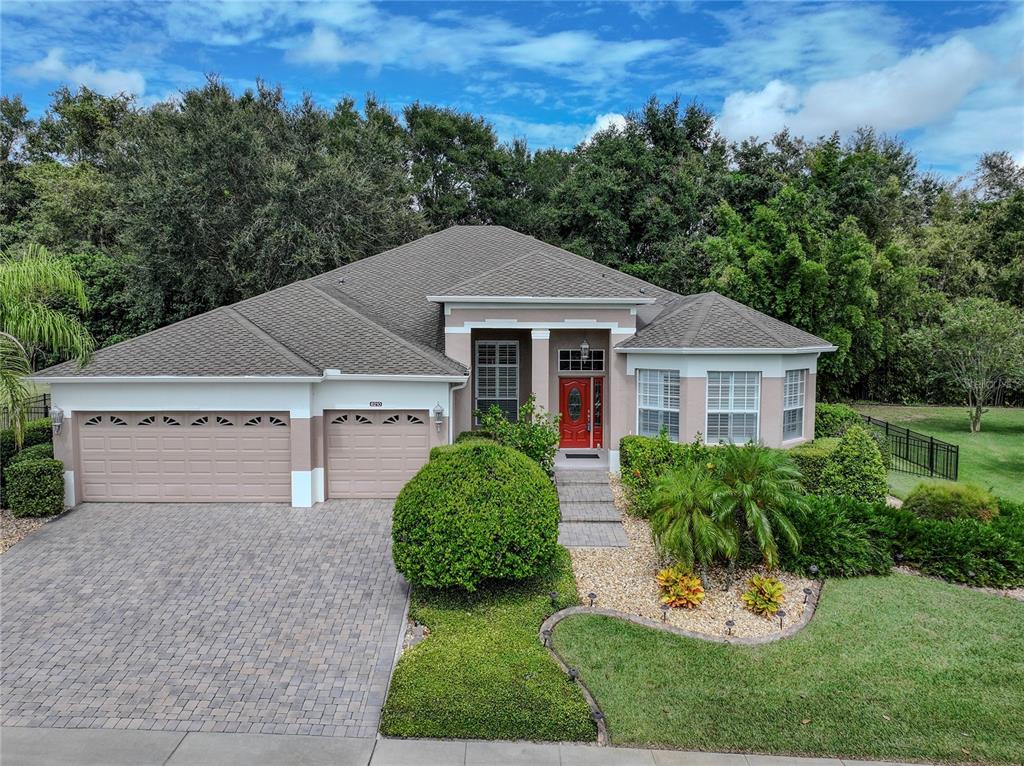 a front view of a house with a yard and trees