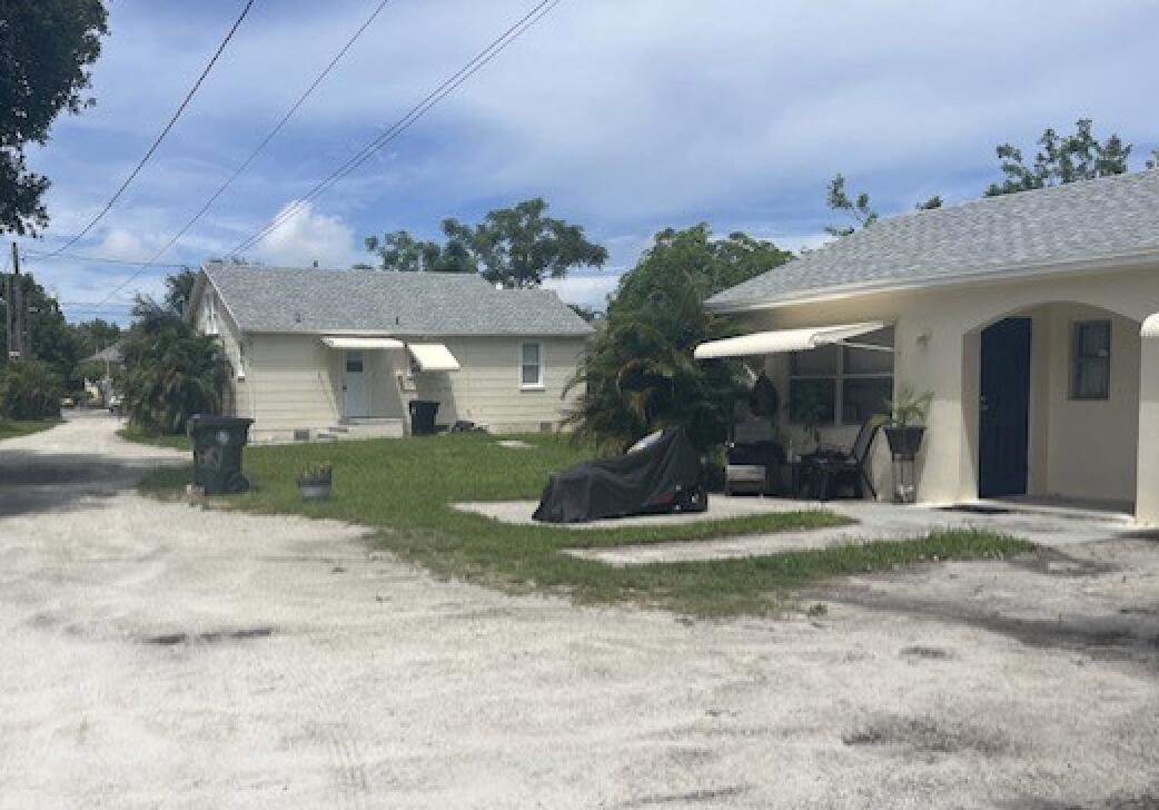 a view of a house with a yard and potted plants