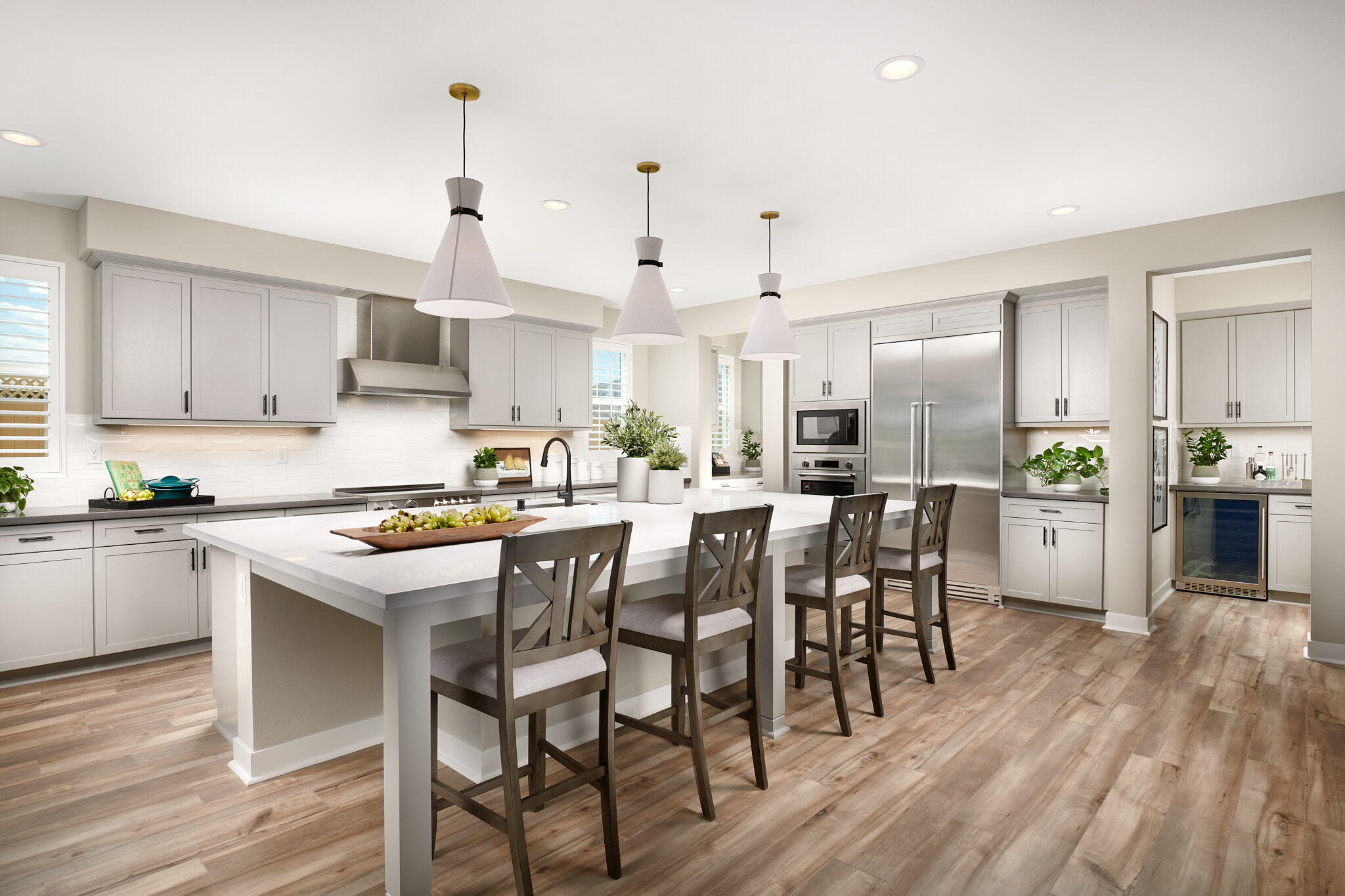 a kitchen with kitchen island granite countertop wooden floors and white cabinets