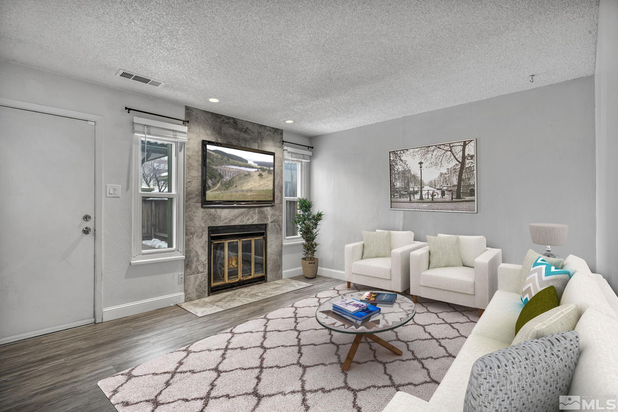 a living room with furniture a flat screen tv and a fireplace