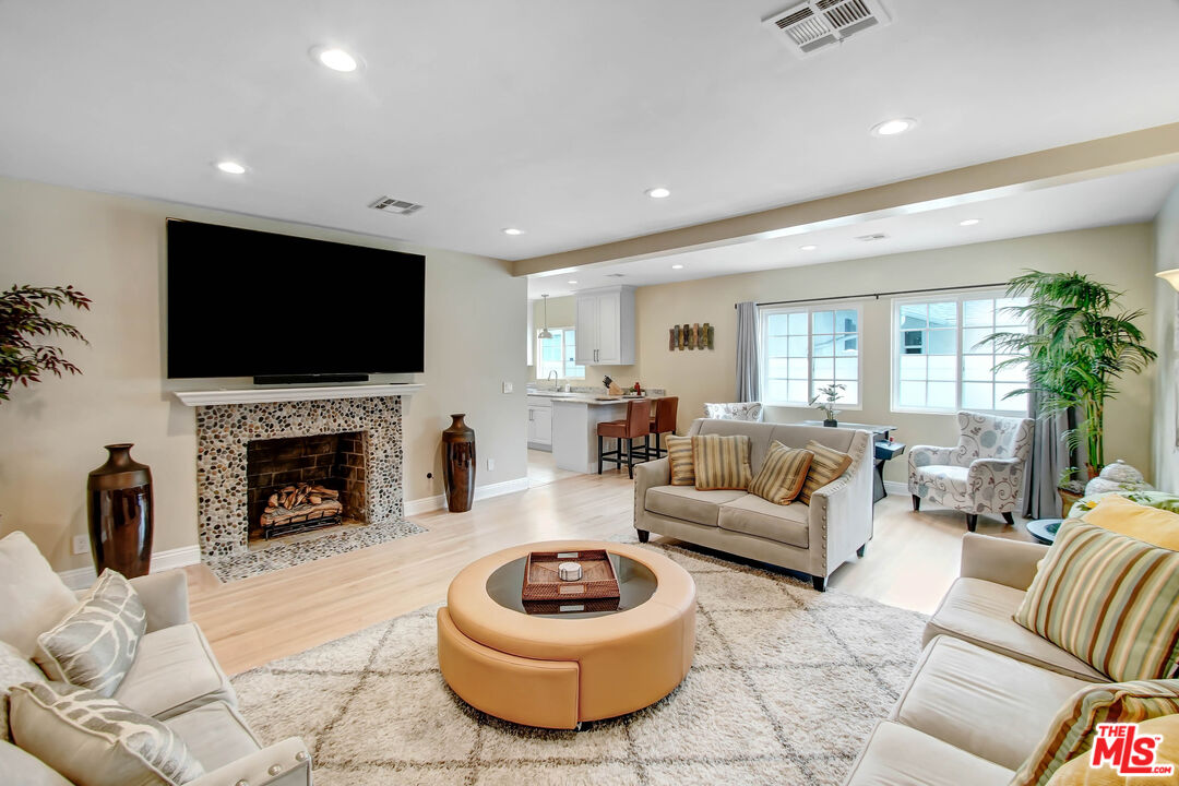 a living room with furniture a fireplace and a flat screen tv