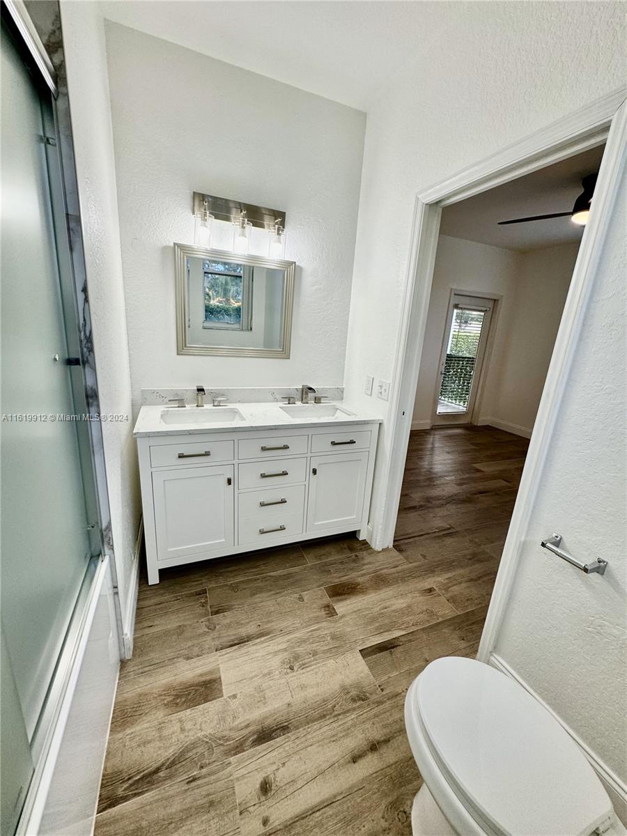 a bathroom with a sink mirror vanity and toilet