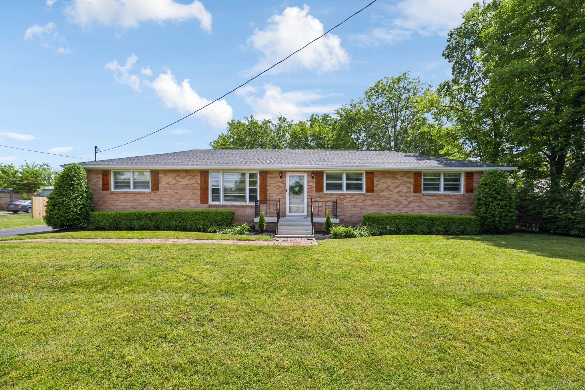 a front view of a house with yard and green space