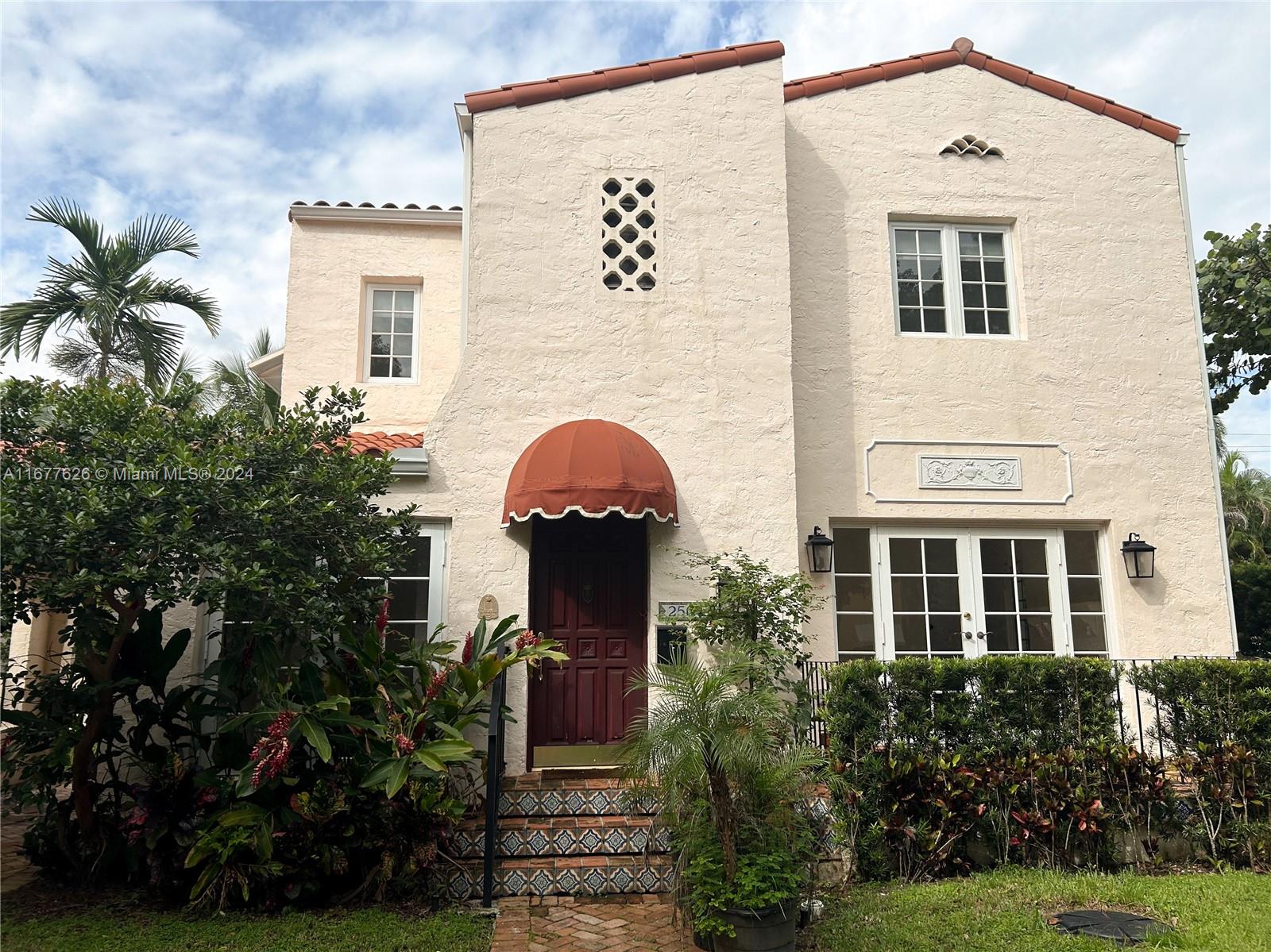 a front view of a house with a yard and trees