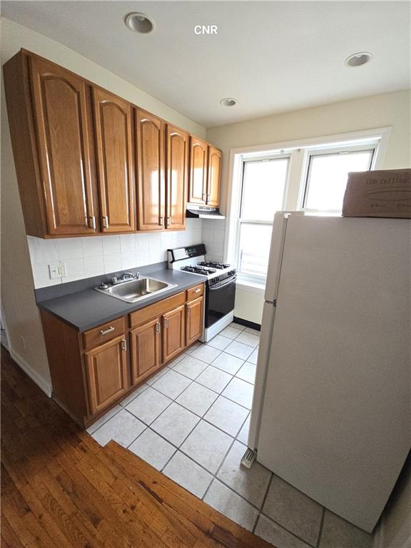 a kitchen with stainless steel appliances granite countertop a stove a sink dishwasher and a refrigerator