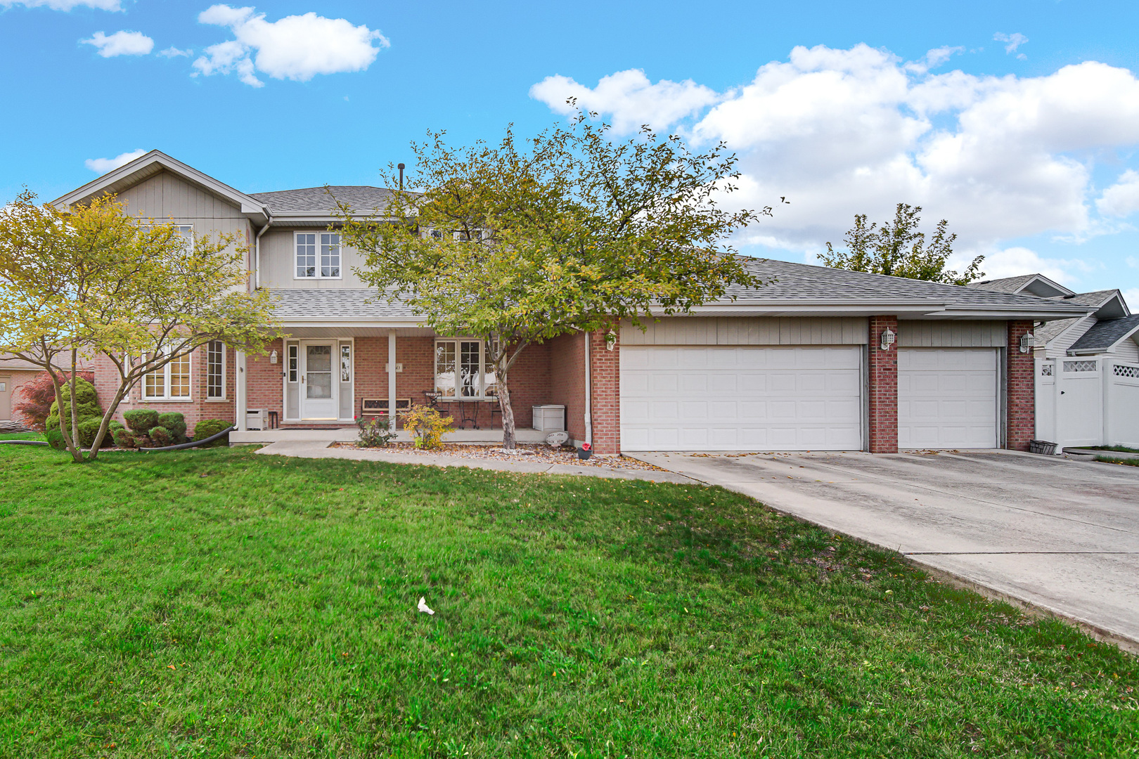 a front view of a house with yard and green space