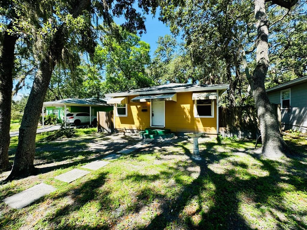 a view of a house with backyard sitting area and garden