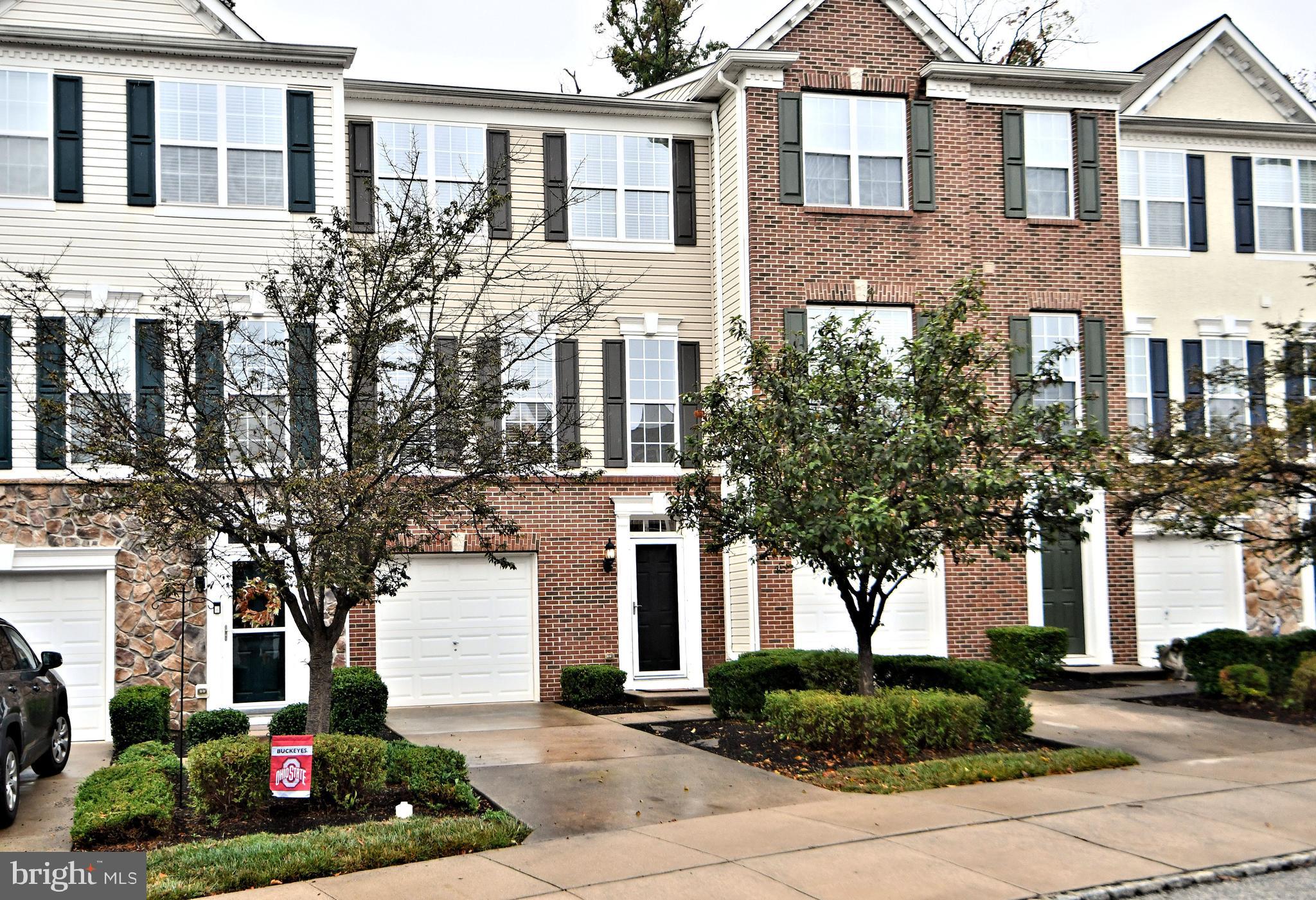 a front view of a residential houses with yard and green space