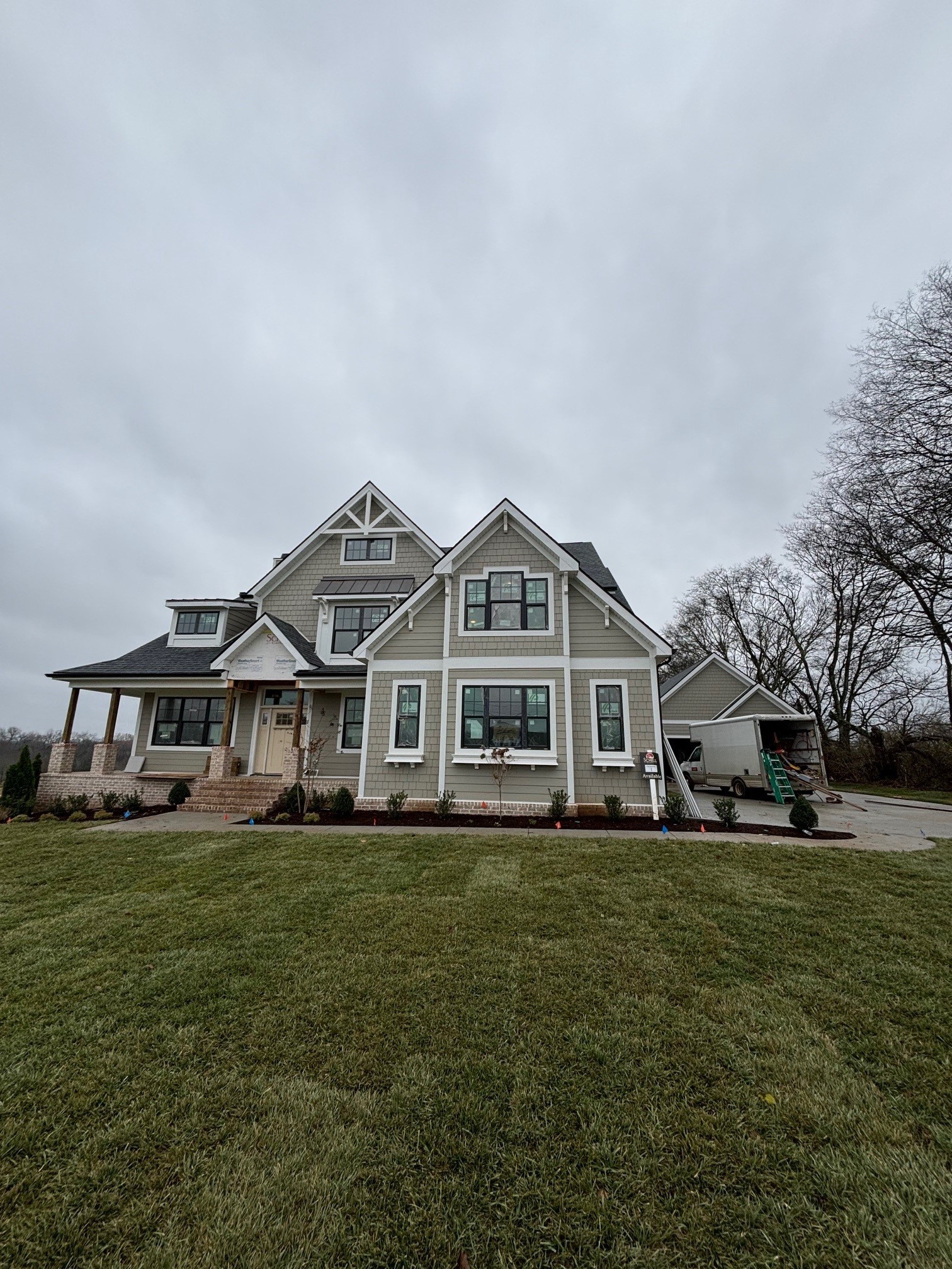 a front view of a house with a yard and trees