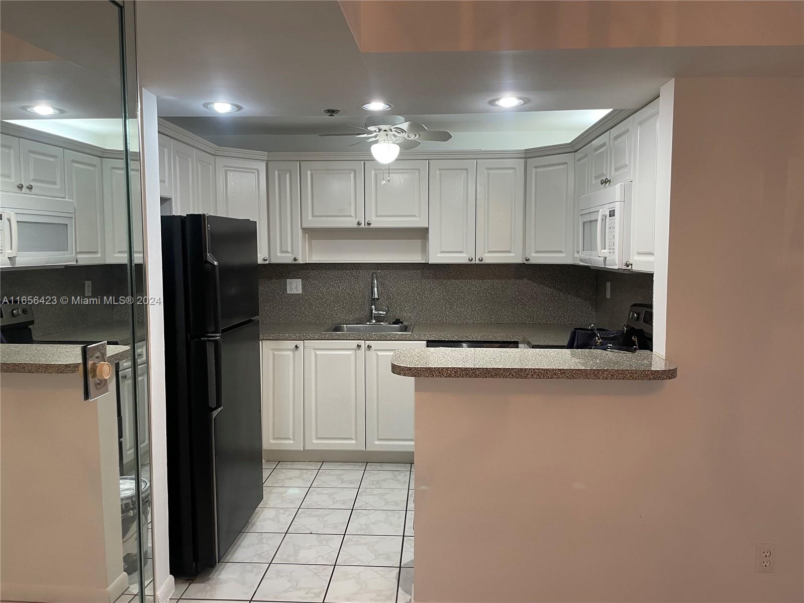 a kitchen with stainless steel appliances granite countertop a refrigerator and a stove